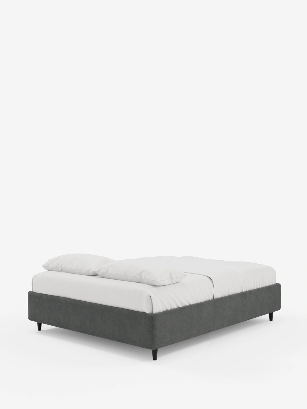 Il letto sommier imbottito ERON con contenitore in tessuto impermeabile certificato Oeko-Tex è un letto dal profilo basso con una struttura grigio scuro poggiata su quattro gambe cilindriche corte di colore nero, rivestito con lenzuola bianche su uno sfondo bianco sporco.