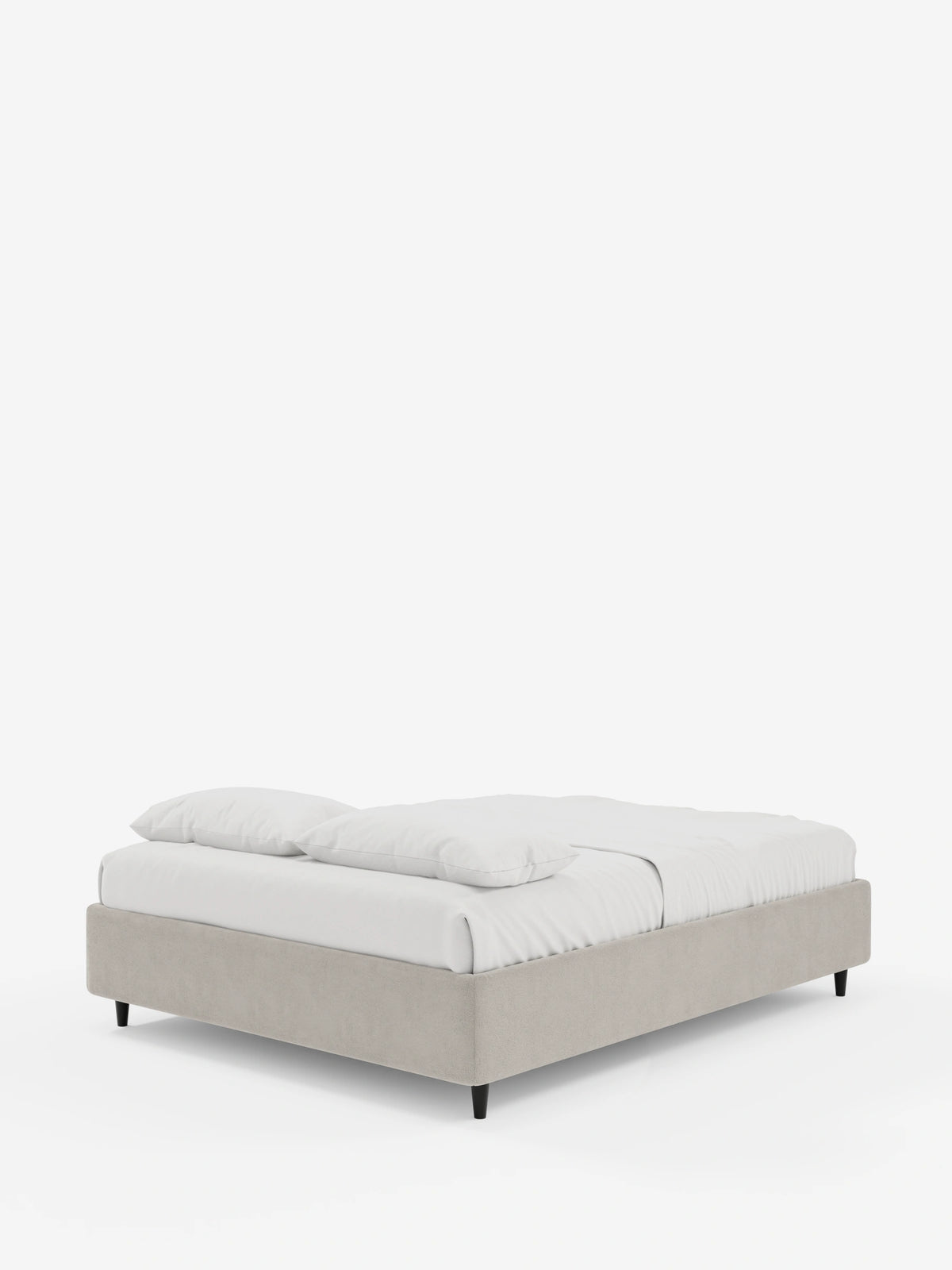 Un letto a sommier imbottito ERON con contenitore, rivestito in tessuto impermeabile certificato Oeko-Tex: questa moderna struttura in tessuto beige poggia su gambe corte e nere, è adornata da lenzuola bianche immacolate e due cuscini, il tutto su uno sfondo a tinta unita.