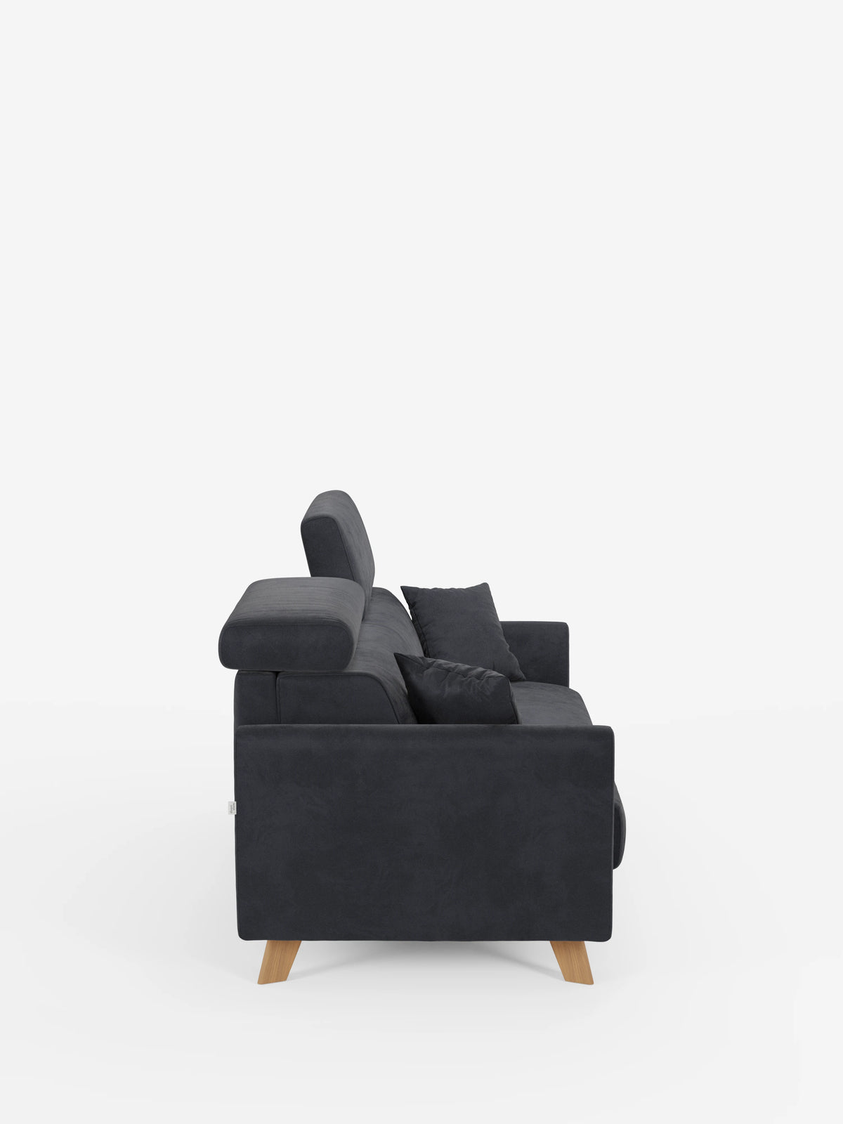 Ecco una vista laterale del divano letto Francy con poggiatesta regolabili di Divani.Store, qui raffigurato in grigio scuro, caratterizzato da poggiatesta regolabili, cuscini decorativi coordinati e gambe angolate in legno. Questo moderno divano a tre posti è completamente sfoderabile e rivestito con un elegante tessuto T30 antimacchia, che risalta sullo sfondo bianco a tinta unita.