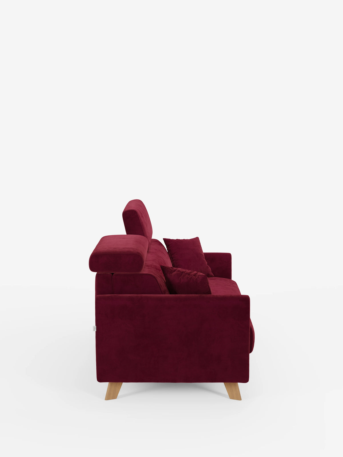 Una vista laterale del divano letto Francy con poggiatesta regolabili di Divani.Store, rivestito in tessuto T30 rosso intenso, elegante e resistente alle macchie. Questo moderno divano a tre posti presenta gambe in legno chiaro, rivestimenti completamente sfoderabili, poggiatesta regolabili e due cuscini abbinati in rosso, il tutto su uno sfondo bianco a tinta unita.