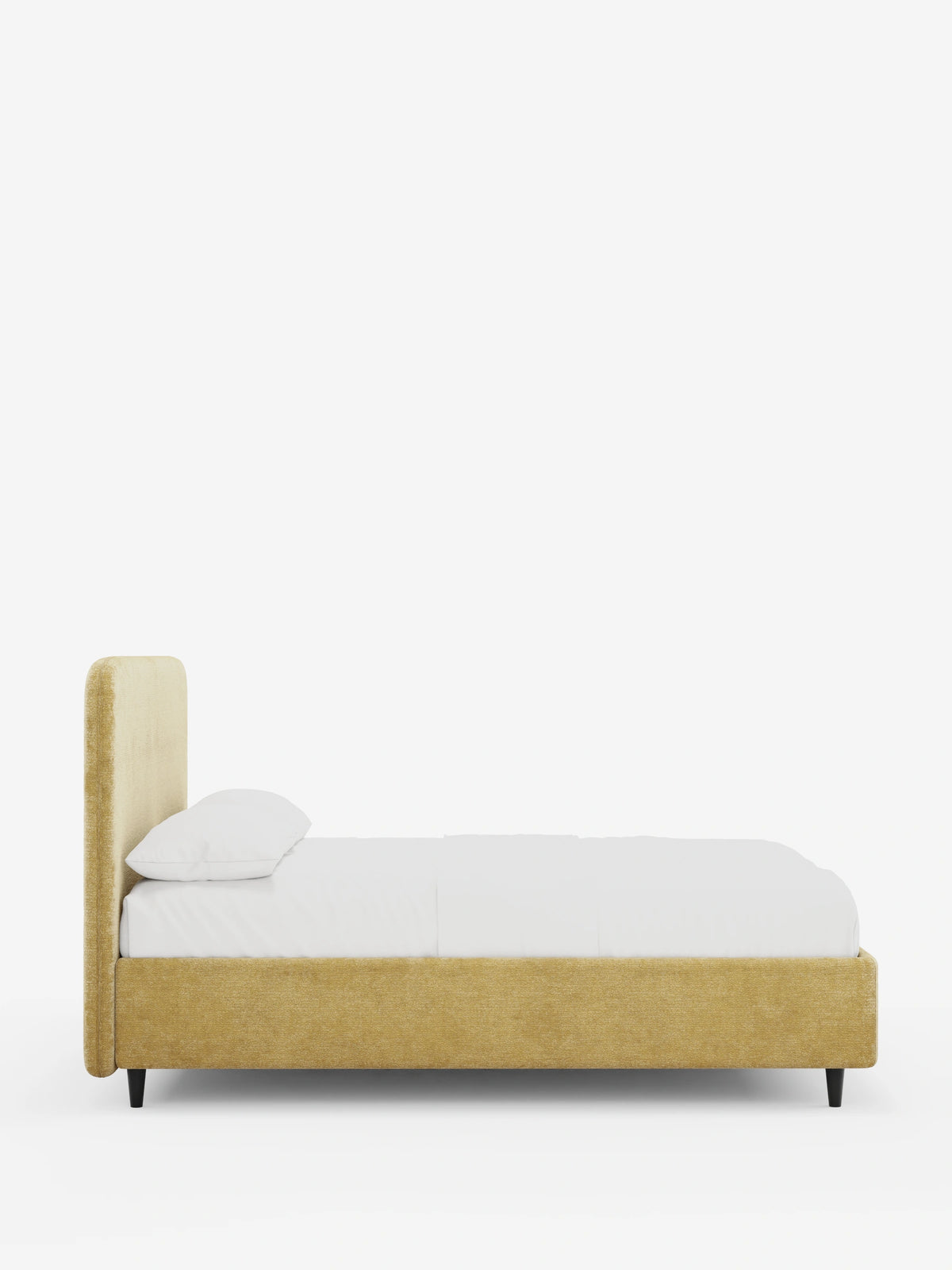 Una vista laterale del letto KAELOS minimal imbottito - con contenitore, gambe alte e testiera arrotondata in tessuto ciniglia, caratterizzato da una testiera arrotondata color senape, base con contenitore, cuscino bianco e sottili gambe nere su sfondo bianco.