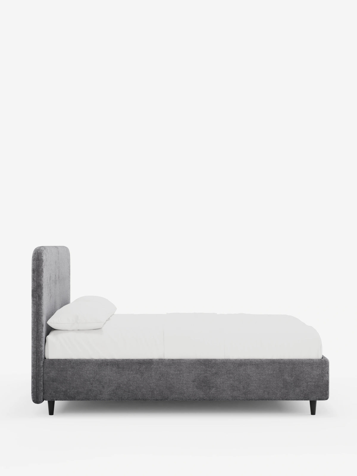 Una vista laterale del letto imbottito KAELOS Letto Minimal, caratterizzato da una struttura in tessuto grigio testurizzato, una testiera arrotondata, biancheria da letto bianca con un cuscino e quattro sottili gambe nere su uno sfondo bianco a tinta unita.