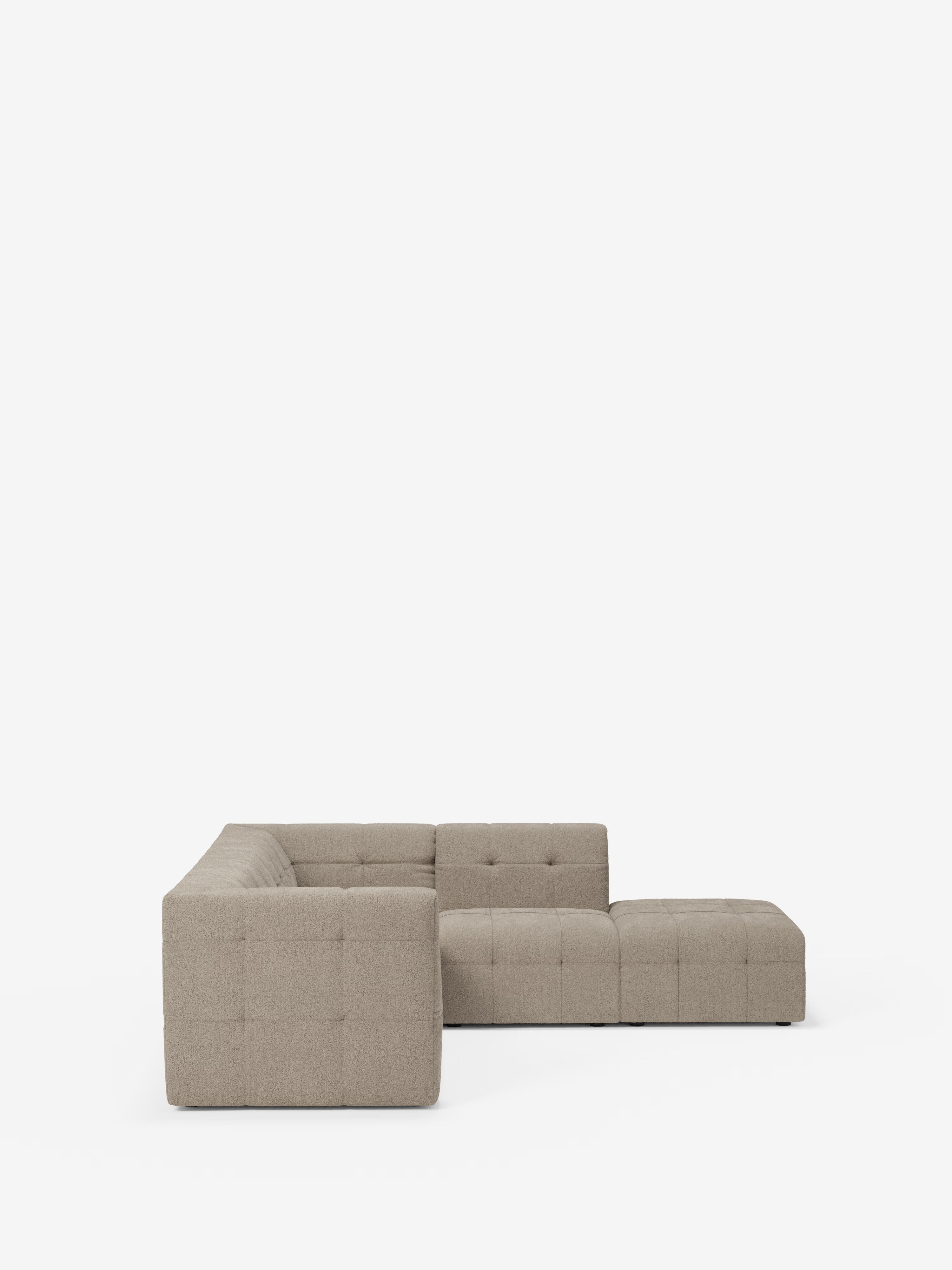 Un divano angolare componibile e modulare Mosaic in bouclé, dal design contemporaneo e dal colore beige, firmato Divani.Store, è raffigurato su uno sfondo bianco. Caratterizzato da cuscini capitonné e realizzato in tessuto T21 resistente alle macchie, questo moderno divano componibile offre una seduta ribassata dalle linee pulite e minimaliste, senza gambe a vista: l'ideale per un soggiorno moderno. L'immagine mostra il divano da un'angolazione laterale diretta.