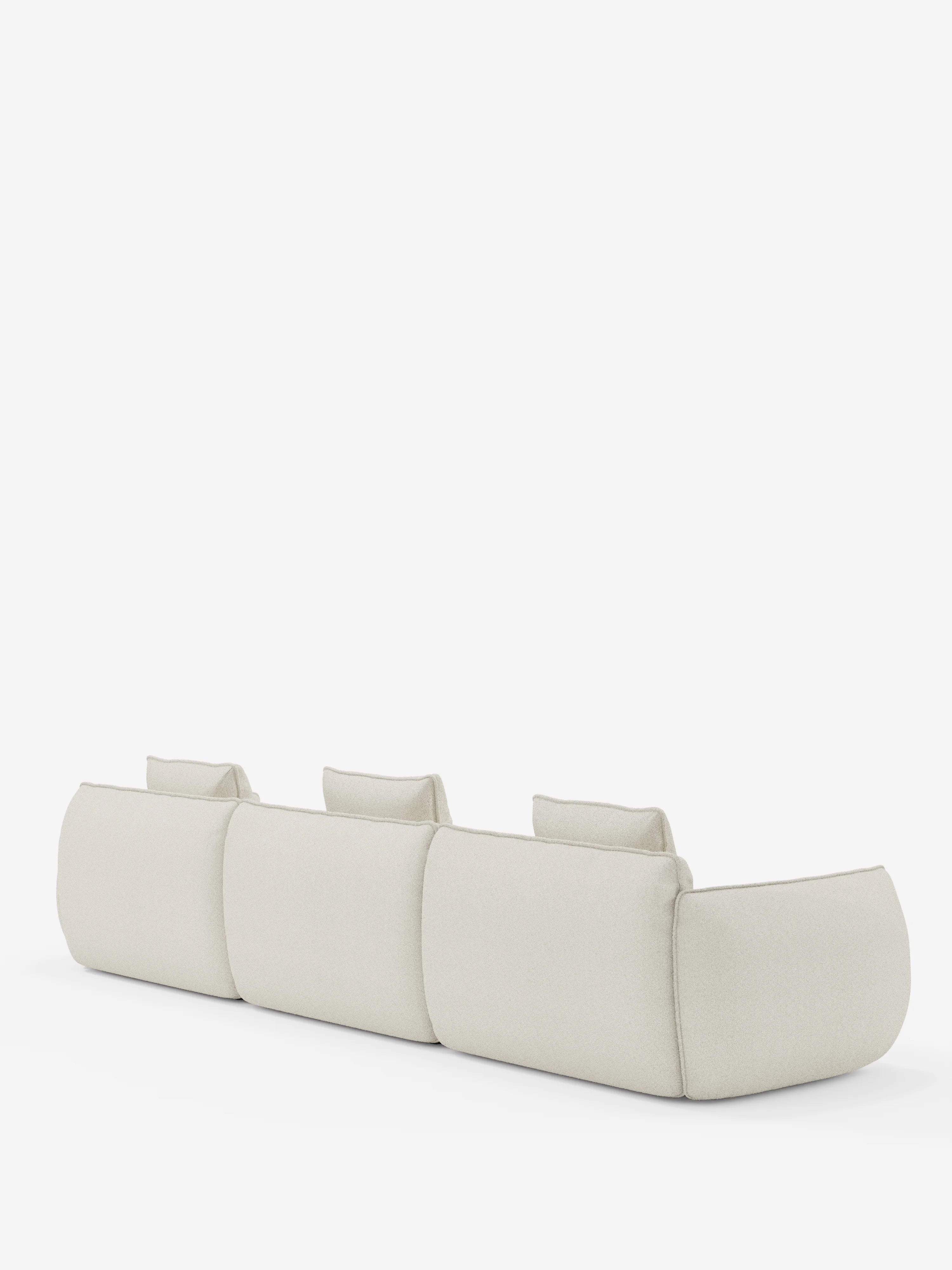 Il divano modulare Nimbus a 3 posti, di colore beige chiaro, realizzato in morbido tessuto smacchiabile effetto cotone T33 di Divani.Store, è raffigurato di spalle su uno sfondo bianco. Ogni seduta è dotata di uno schienale rettangolare indipendente e di braccioli bassi e larghi. Il design minimalista conferisce al divano un aspetto lussuoso e accogliente.