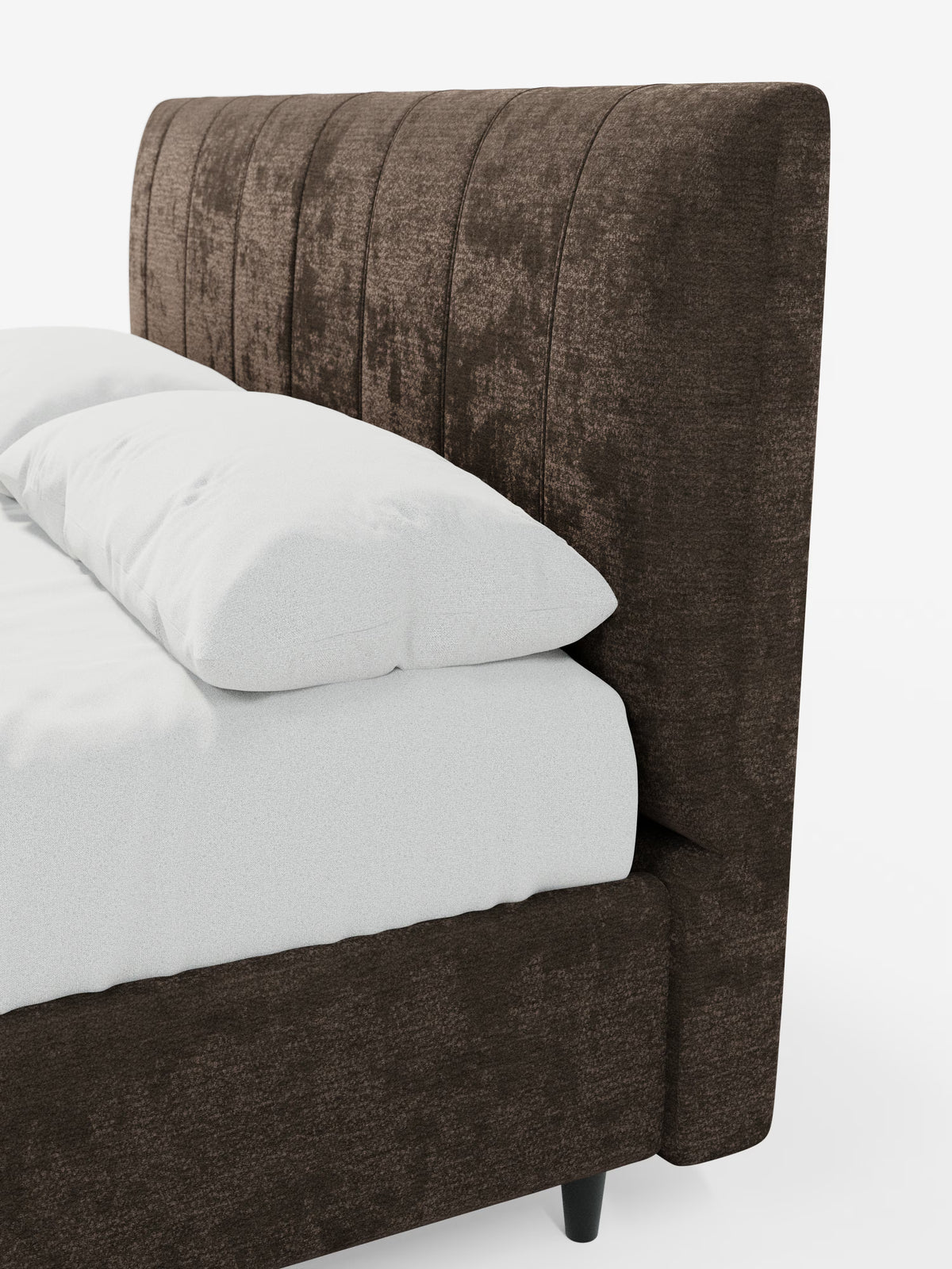 Un primo piano del letto imbottito ONYX con contenitore e testiera verticale in tessuto certificato Oeko-Tex® di Letti.store mostra una testiera alta, a pannelli verticali, rivestita in tessuto testurizzato marrone scuro. Il letto è abbinato a biancheria da letto e cuscini bianchi, poggia su gambe corte nere ed è posizionato su uno sfondo bianco a tinta unita.