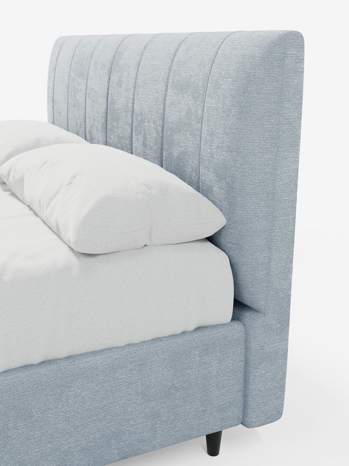 Una vista laterale ravvicinata del letto imbottito ONYX con contenitore e testiera verticale in tessuto certificato Oeko-Tex® di Letti.store, caratterizzato da una testiera imbottita azzurra con cuciture verticali, biancheria da letto bianca e gambe affusolate nere, su uno sfondo bianco a tinta unita.