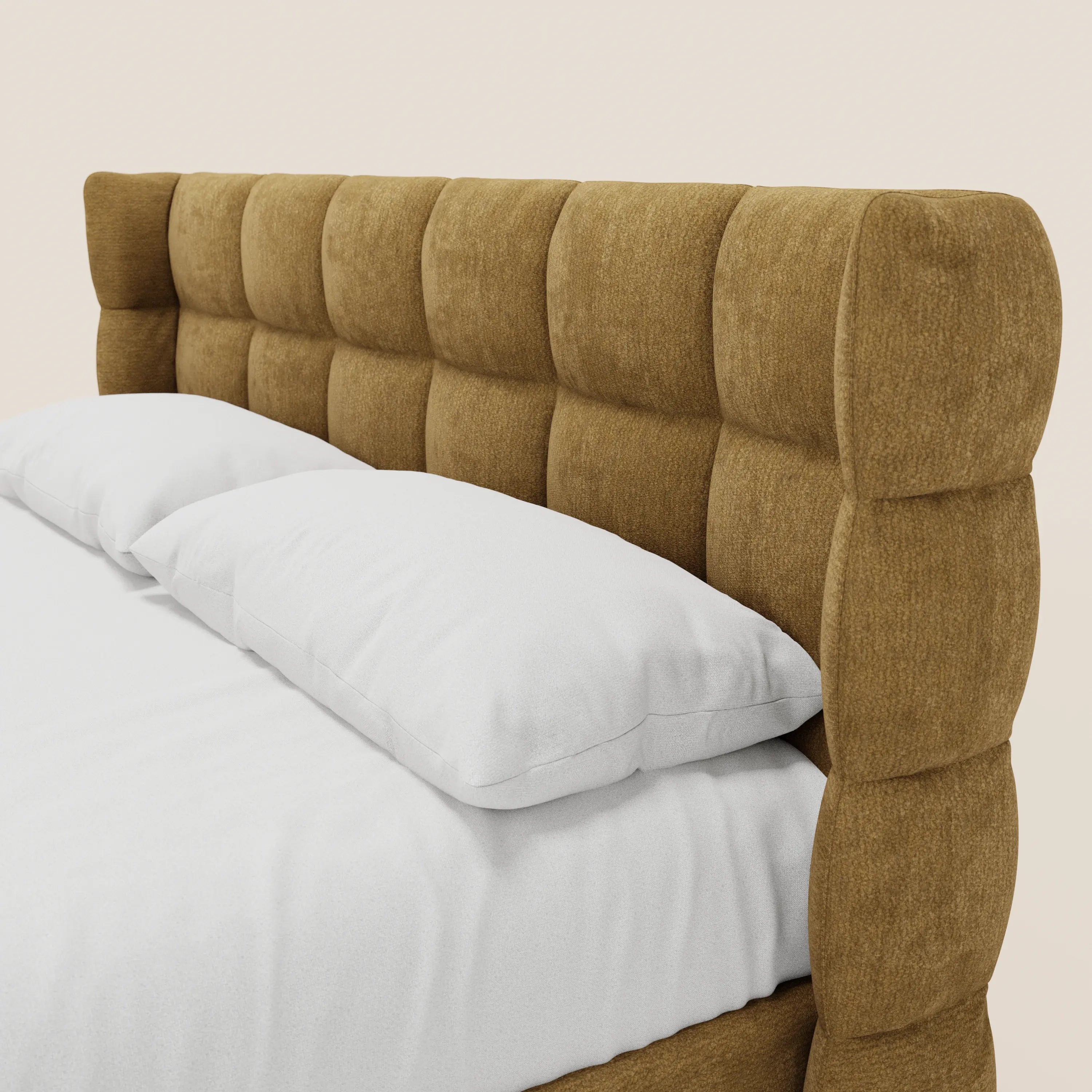 Un primo piano del letto imbottito RAGNAR con contenitore e testiera capitonné avvolgente di Letti.store, realizzato in tessuto marrone chiaro testurizzato certificato Oeko-Tex®, rifinito con cura con cuscini e coperta bianchi, su uno sfondo chiaro e uniforme.