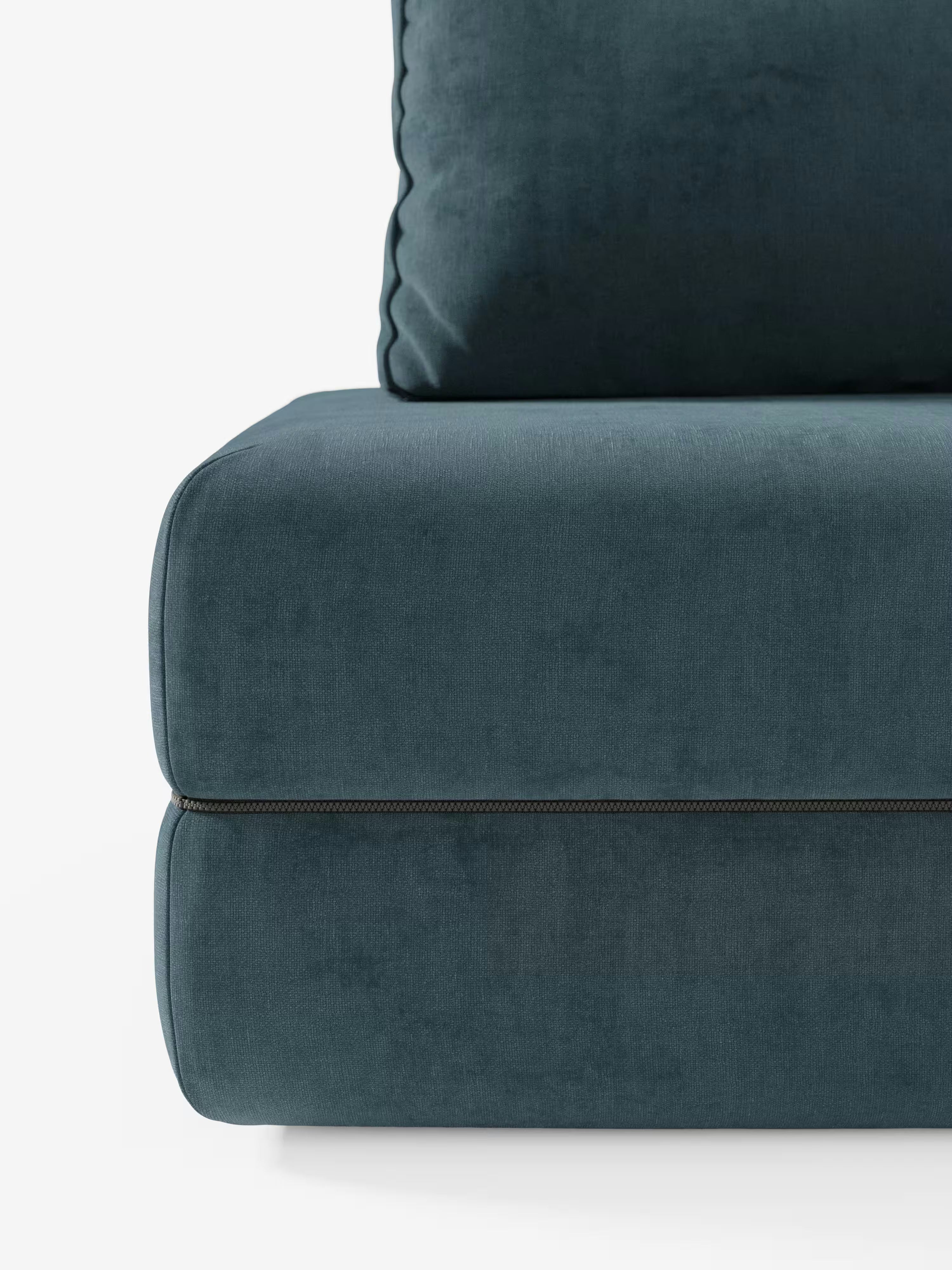 Primo piano del divano letto matrimoniale Rift di Divani.Store, qui presentato in verde acqua scuro, che mette in risalto il cuscino di seduta e lo schienale inferiore con cuciture a vista e una vistosa cerniera orizzontale lungo il bordo inferiore. Dotato di schienali mobili e rivestito in tessuto T31 resistente alle macchie, questo elegante divano letto a 2 o 3 posti con un materasso in memory foam alto 24 cm è perfetto per qualsiasi ambiente moderno. Lo sfondo è bianco a tinta unita.