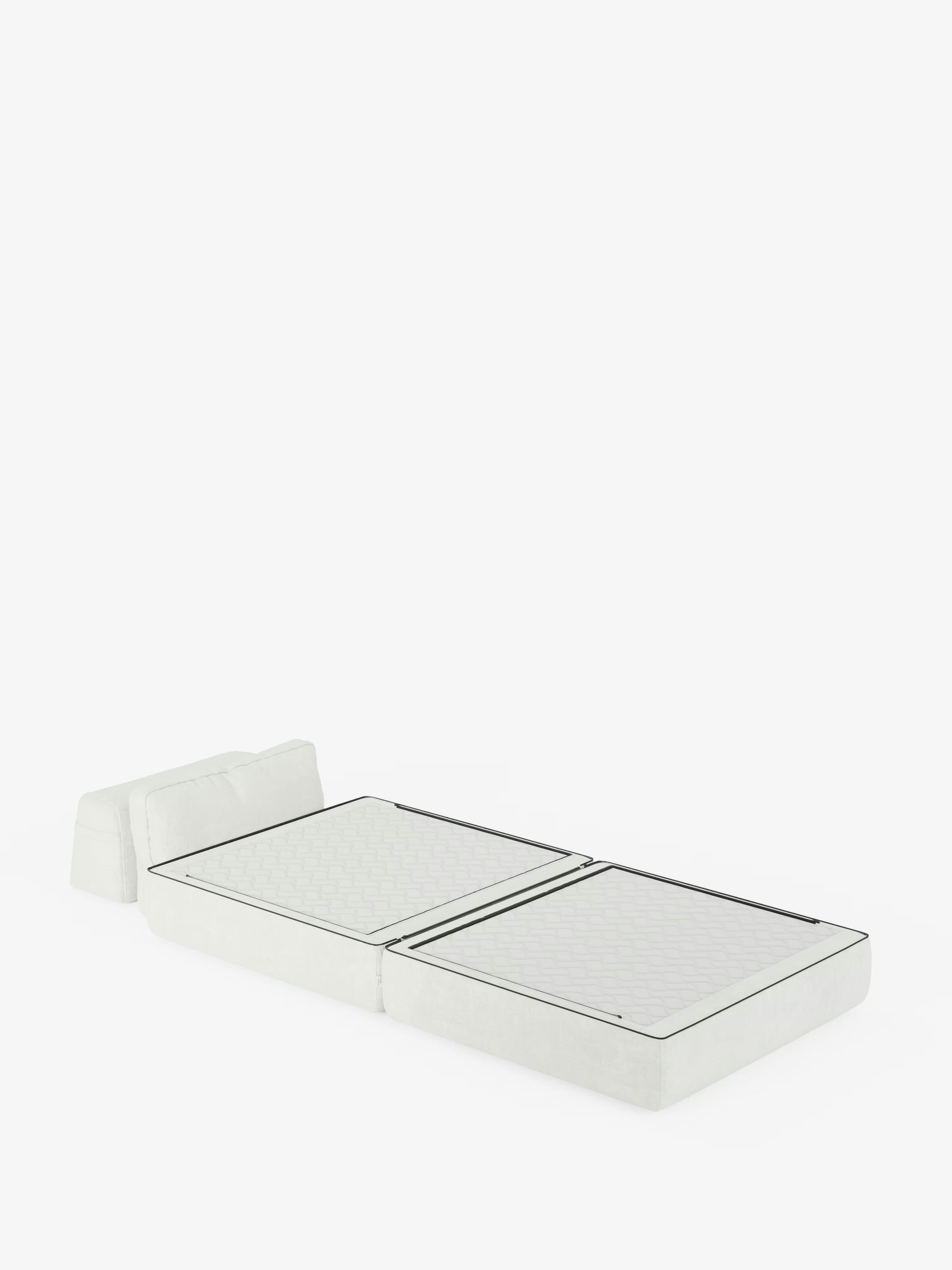 Una poltrona letto Rift bianca in stile minimalista di Divani.Il modello, dotato di schienale mobile e rivestito in tessuto T31 antimacchia, si trasforma in un letto singolo piatto per gli ospiti con un materasso in memory foam dello spessore di 24 cm e due cuscini di seduta che ne costituiscono la superficie: un'elegante soluzione trasformabile che si distingue su uno sfondo bianco a tinta unita.