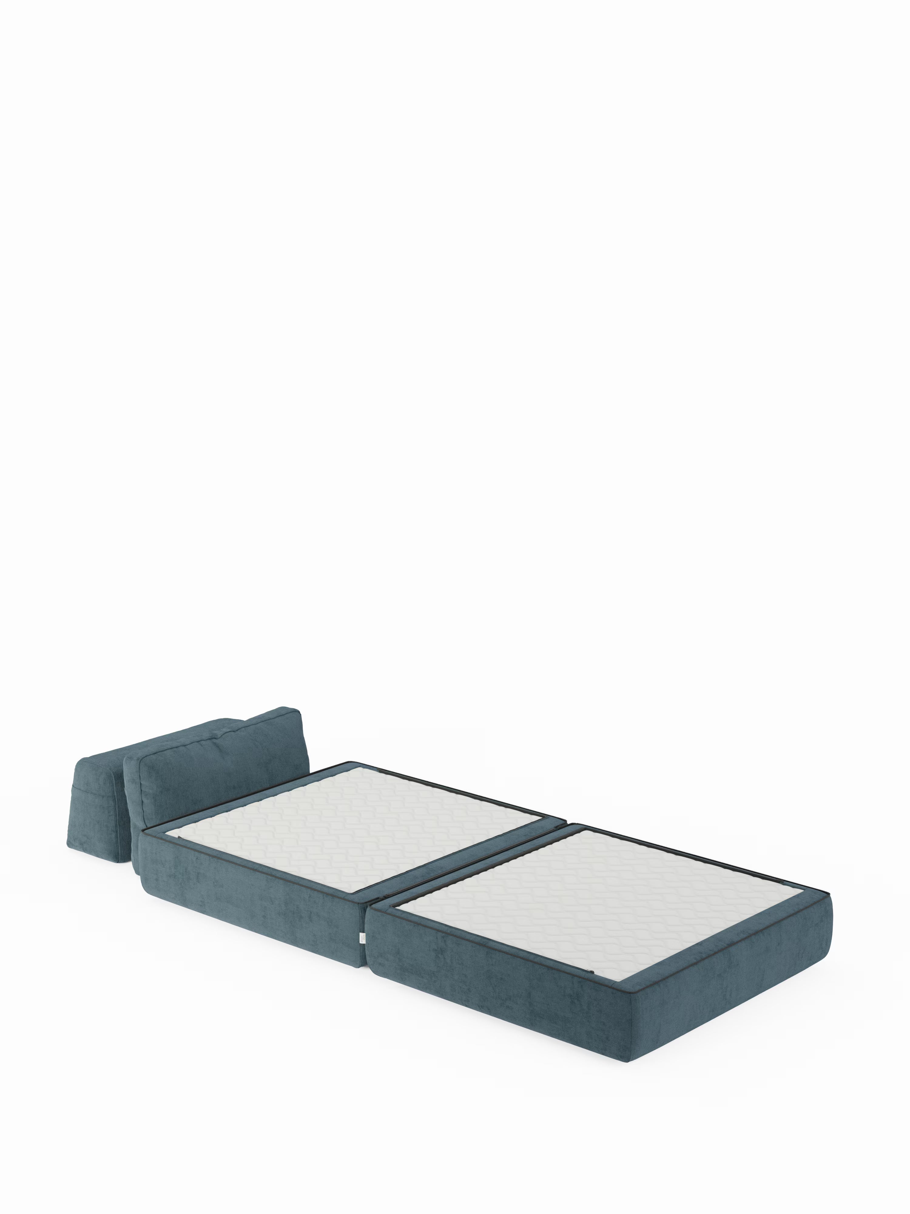 La poltrona letto Rift con materasso alto 22 cm e memory foam di Divani.Store è raffigurata aperta in posizione da letto, con due sezioni imbottite che formano il materasso e un cuscino separato che funge da cuscino per la testa. Lo schienale mobile e il rivestimento in tessuto T31 antimacchia risaltano su uno sfondo completamente bianco, mettendo in risalto la forma e le caratteristiche del mobile.