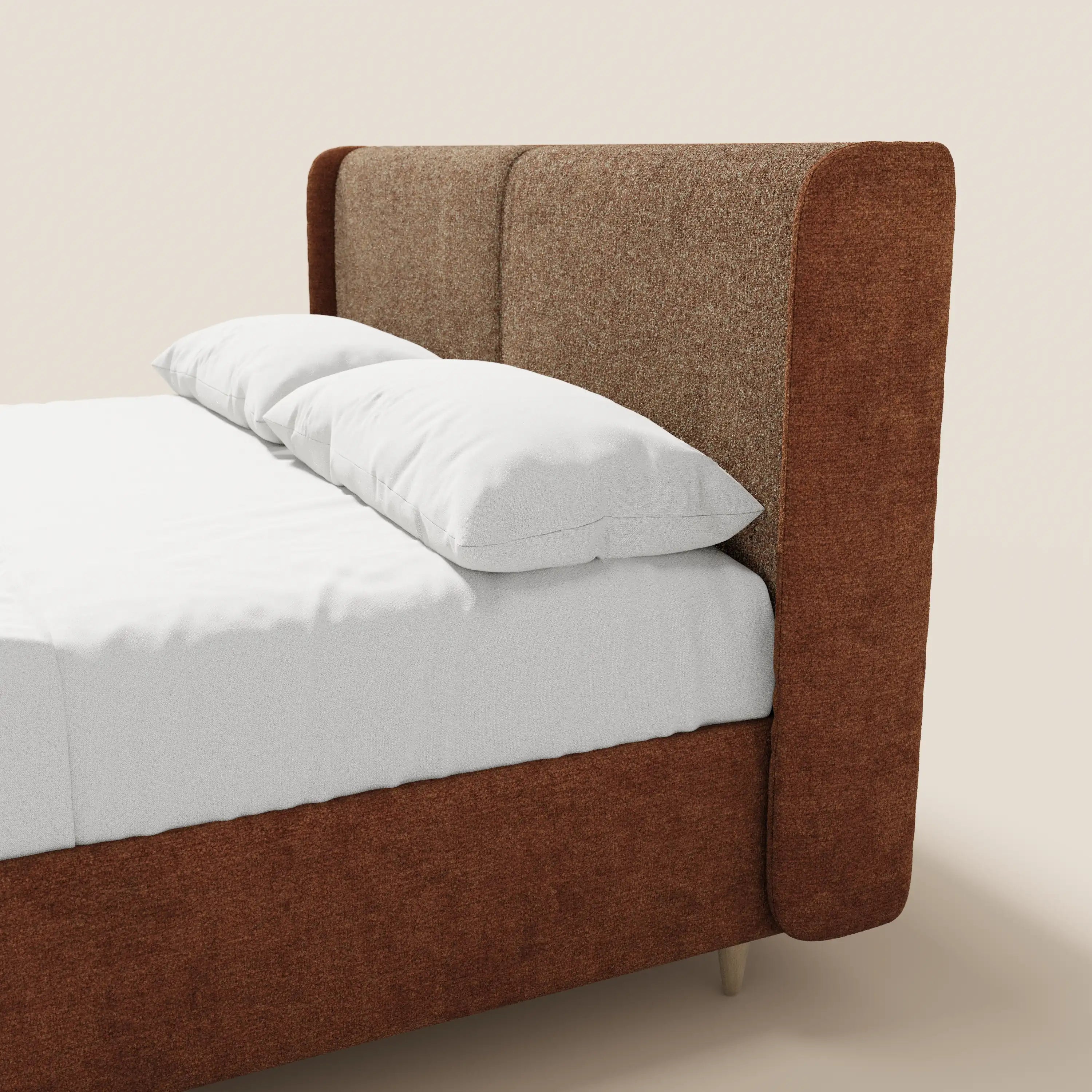 Il letto imbottito bicolore VALKIRIA di Letti.store presenta una testiera curva e avvolgente rivestita in tessuto testurizzato bicolore marrone, in tinta con la struttura. Lenzuola bianche e due cuscini completano il look minimalista su uno sfondo beige neutro.