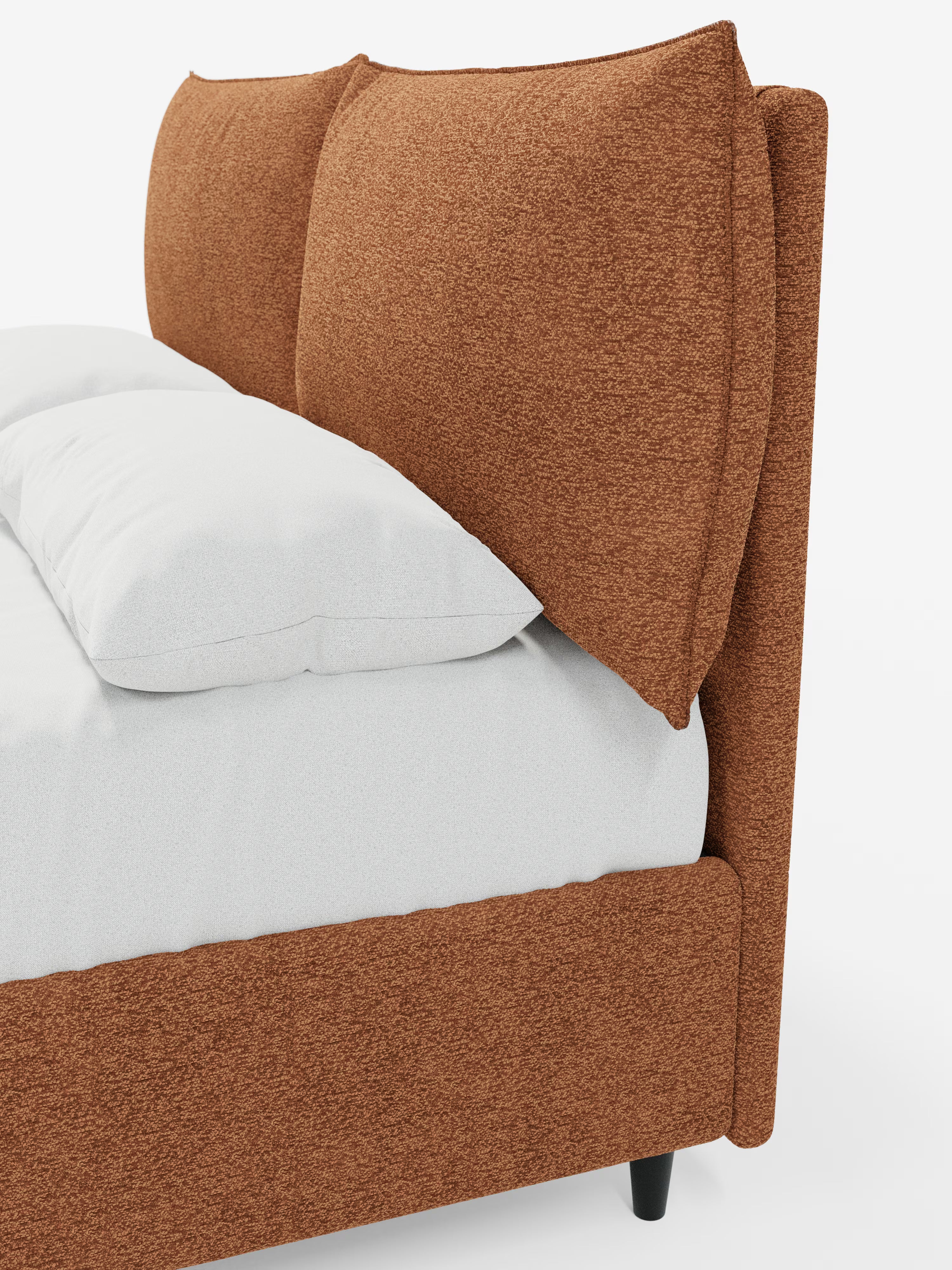 Vista di profilo del letto imbottito ZAYRON con contenitore e morbidi cuscini regolabili di Letti.store, caratterizzato da una struttura in tessuto testurizzato color ruggine, certificato Oeko-Tex®, e da cuscini oversize e soffici regolabili sulla testiera. Questo letto dal design moderno è abbinato a biancheria da letto bianca, poggia su corte gambe nere ed è posizionato su uno sfondo bianco a tinta unita.