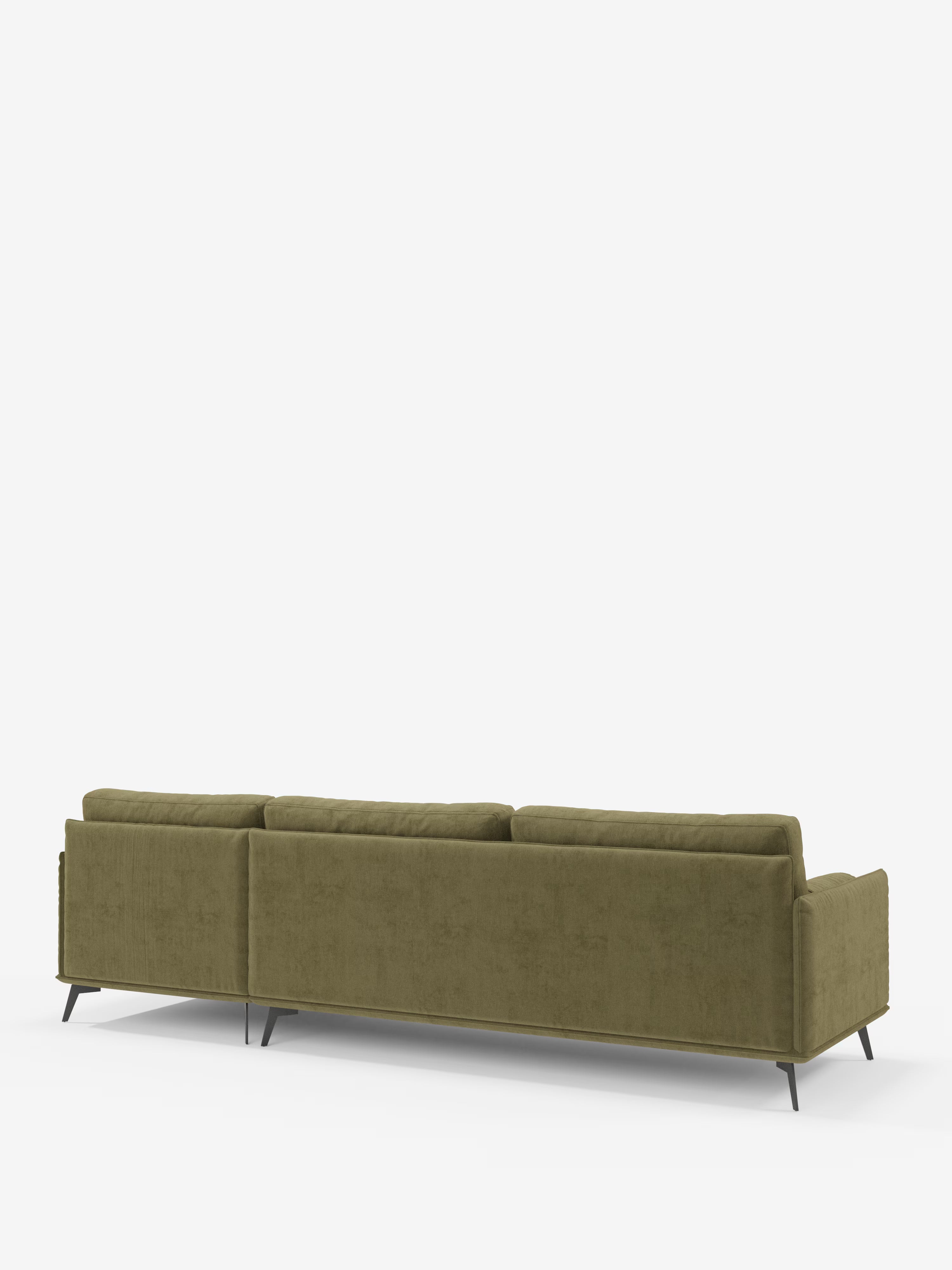 Il divano moderno angolare con penisola Basalto di Divani.Store è ripreso di retro su uno sfondo bianco. Caratterizzato da linee pulite, braccioli sottili, tre cuscini dello schienale e gambe angolari in metallo nero, questo divano moderno verde — rivestito in tessuto T31 antimacchia con cuscini in piuma — incarna uno stile minimalista e contemporaneo. Il suo design raffinato esemplifica l’eleganza tipica dei divani di produzione italiana.