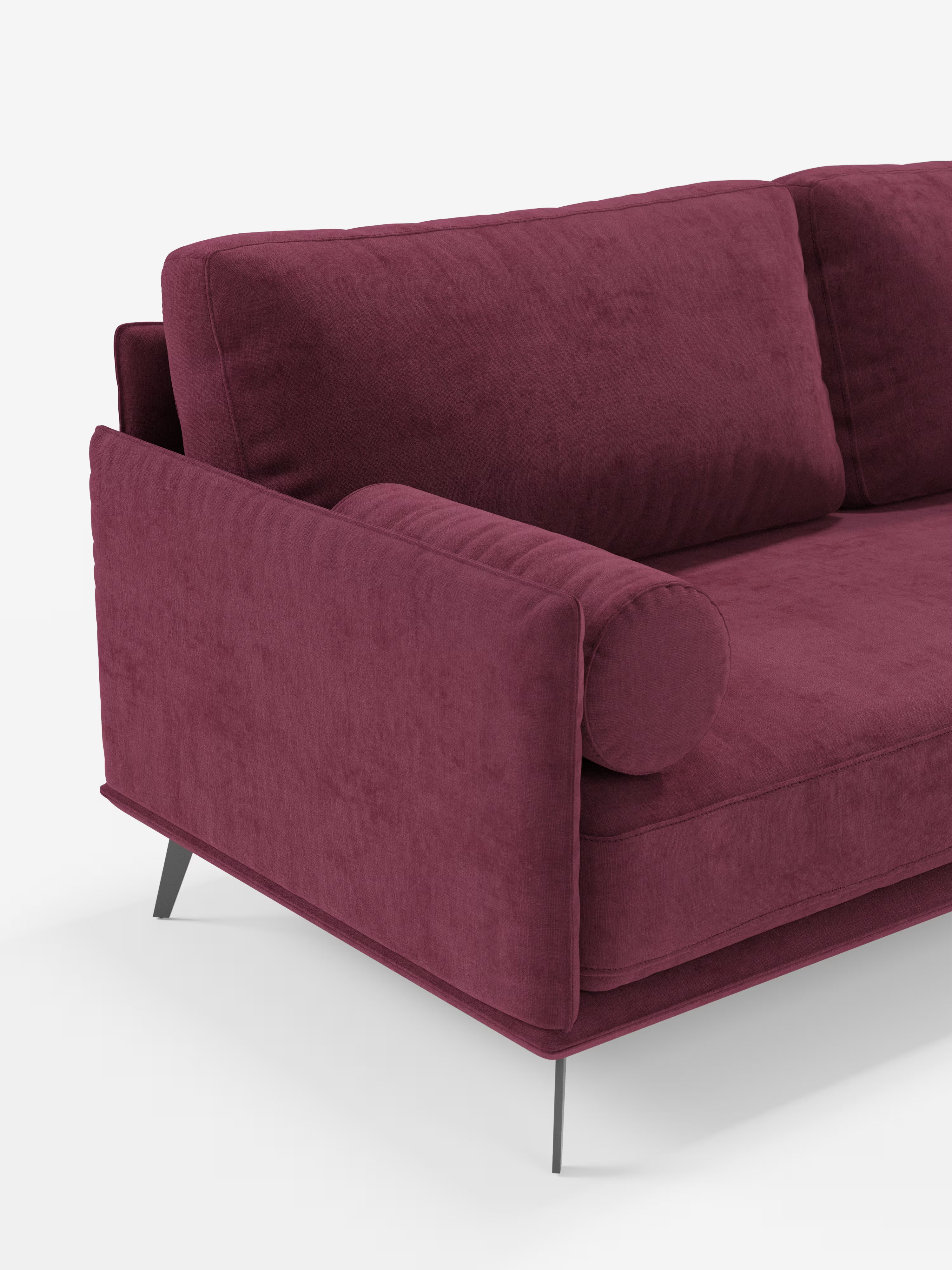 Un primo piano del divano lineare a 2 posti “Basalto” di Divani.Store, rivestito in morbido tessuto T31 color bordeaux, resistente alle macchie. Il divano è caratterizzato da un unico cuscino di seduta, un cuscino dello schienale rettangolare, un cuscino cilindrico abbinato, una base e gambe sottili in metallo nero e linee pulite e dritte. Lo sfondo è bianco a tinta unita.