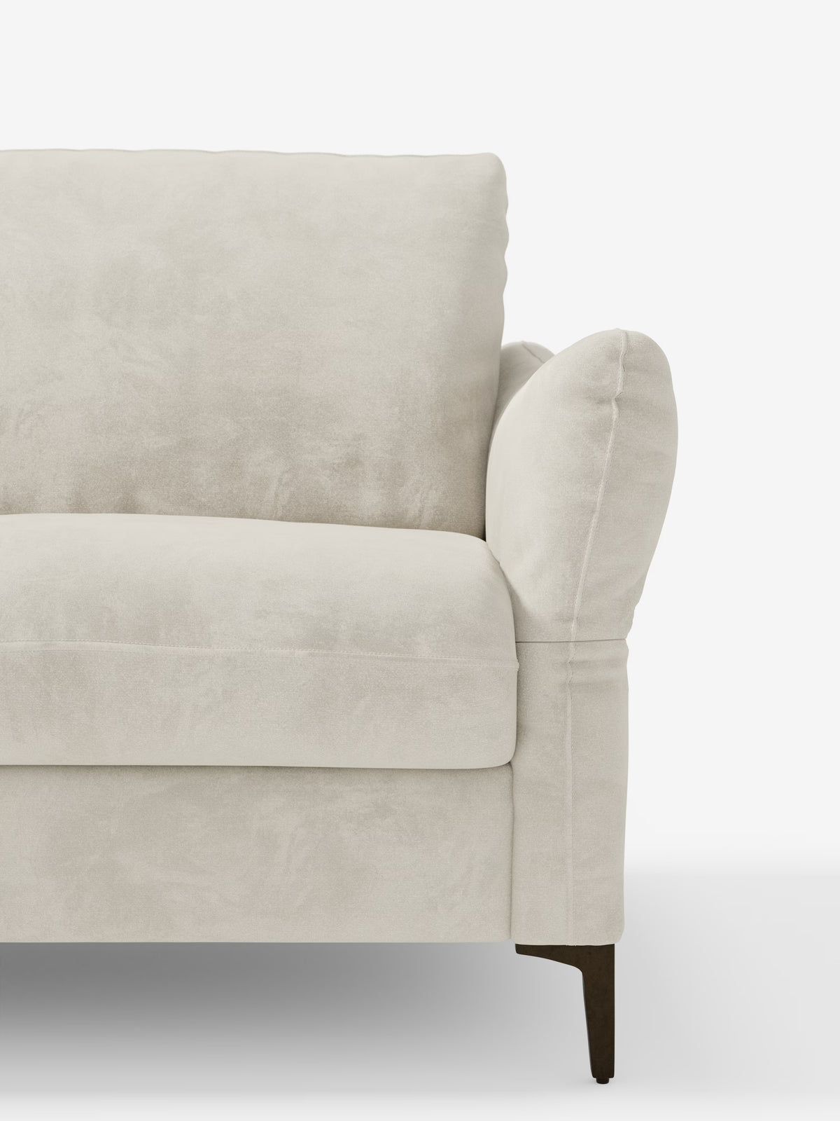 Un primo piano del divano letto Dalia di Divani.Store, un moderno divano beige rivestito in tessuto vellutino smacchiabile T30, ispirato all’eleganza scandinava. L’immagine mette in risalto il bracciolo destro, il morbido cuscino dello schienale e il cuscino della seduta dalla consistenza vellutata, nonché le gambe in legno scuro, il tutto su uno sfondo bianco a tinta unita.
