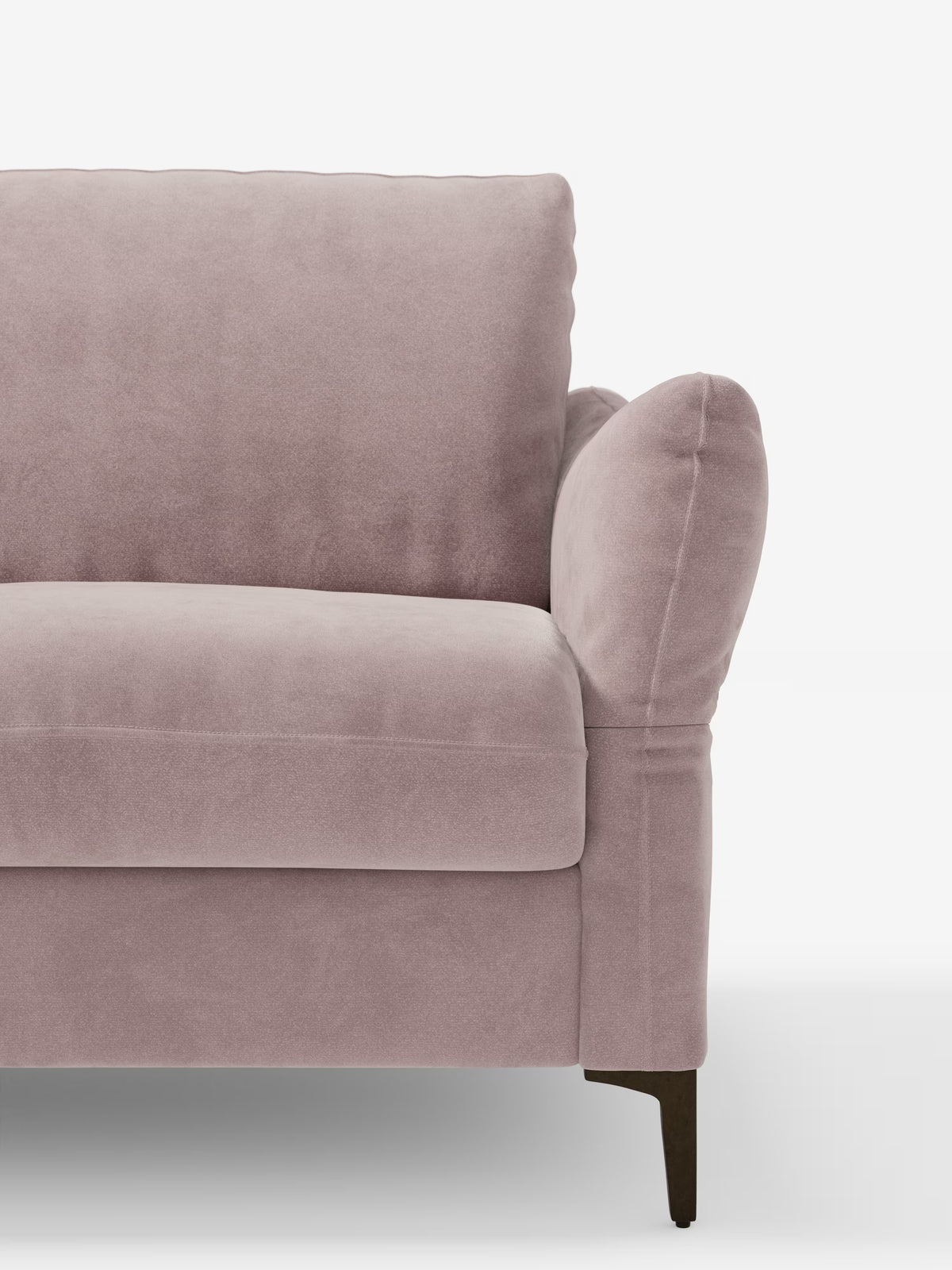 Il divano letto Dalia da 2, 3 e 4 posti in una delicata tonalità di malva chiaro con materasso H18 di Divani.Store è raffigurato dal lato sinistro. Rivestito con il moderno tessuto vellutino T30 resistente alle macchie, questo elegante divano presenta morbidi braccioli arrotondati e cuscini spessi sia per la seduta che per lo schienale. Il divano poggia su una gamba in legno scuro su uno sfondo bianco.