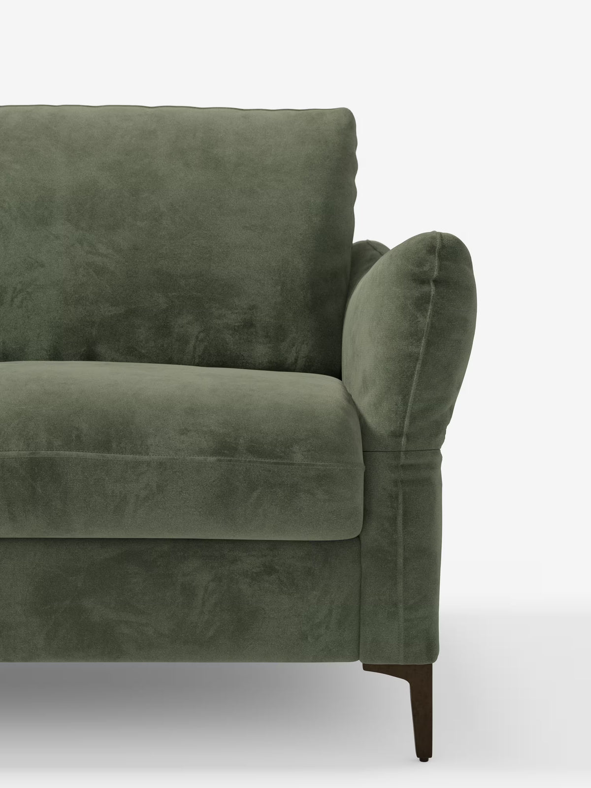 Un primo piano del divano letto Dalia di Divani.Store, qui presentato con un rivestimento in tessuto vellutato moderno T30 di un verde vivace e resistente alle macchie. I braccioli e lo schienale morbidi e arrotondati mettono in risalto la consistenza morbida e vellutata del divano. È visibile solo la metà sinistra di questo divano a 2/3/4 posti con materasso H18; in basso a destra si intravede una gamba in legno scuro su uno sfondo bianco a tinta unita.