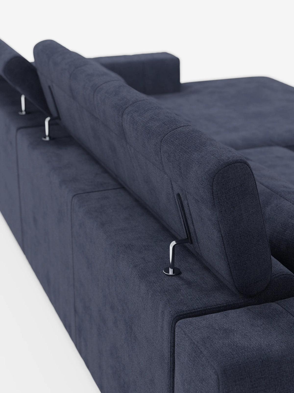 Una vista ravvicinata della parte posteriore del “Doric Divano angolare con penisola e sedute allungabili con relax elettrico” di Divani.Store mette in risalto il suo moderno rivestimento in tessuto blu navy, dotato di poggiatesta regolabili con supporto in metallo e poggiatesta reclinabili rivestiti in tessuto smacchiabile T23. Su uno sfondo bianco, la finitura morbida e strutturata del divano accentua il suo design italiano contemporaneo e le linee pulite.
