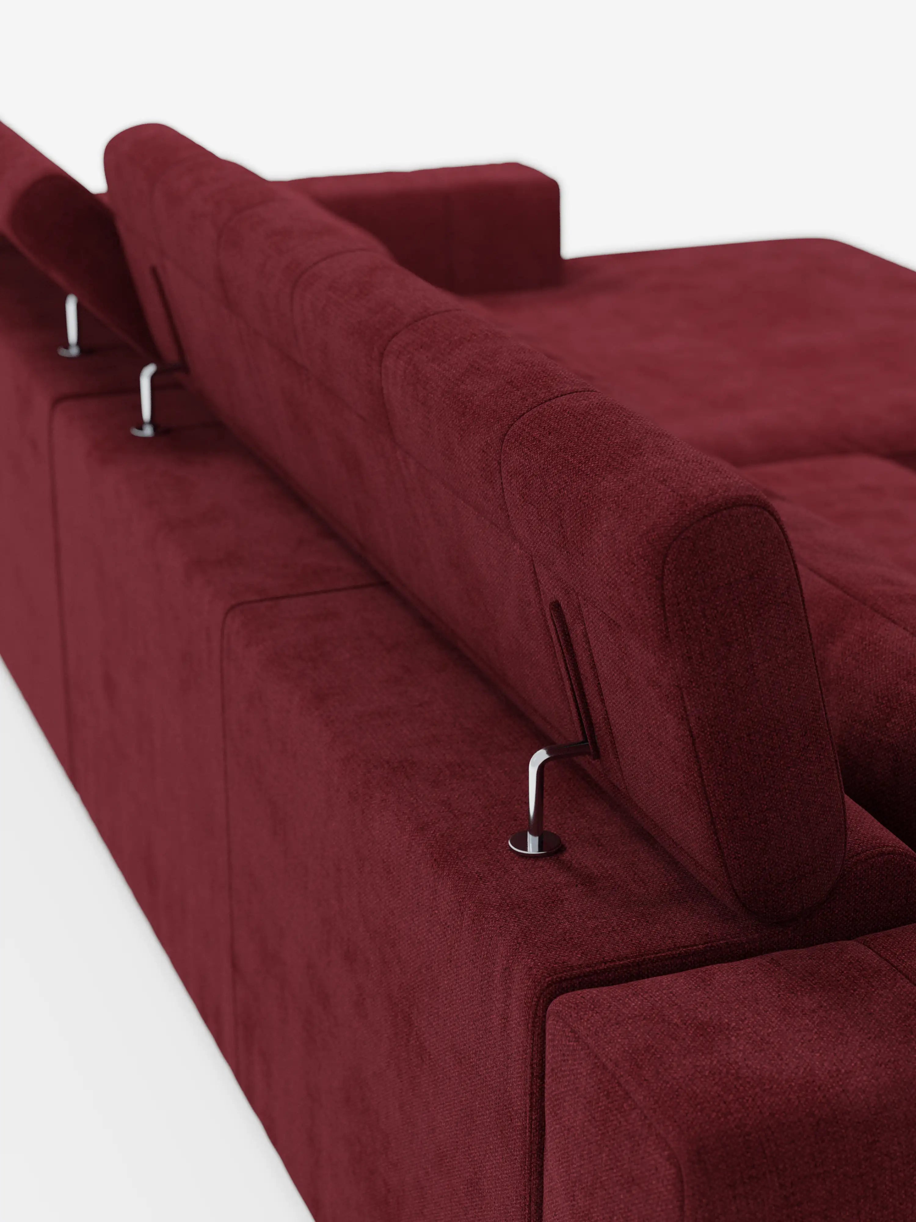 Vista posteriore del divano angolare dorico con penisola e sedute allungabili con funzione relax elettrica di Divani.Store, rivestito in tessuto T23 color bordeaux scuro facile da pulire, dotato di poggiatesta regolabili sostenuti da eleganti aste metalliche. Il divano presenta linee pulite e rettangolari e un aspetto morbido e materico, che risalta sullo sfondo bianco a tinta unita.
