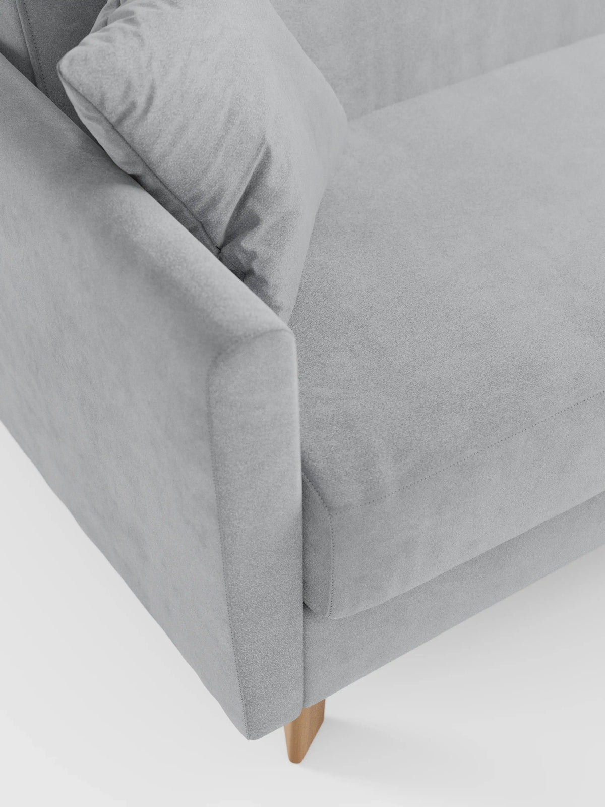 Primo piano del divano letto Francy con poggiatesta regolabili di Divani.Store — rivestimento sfoderabile al 100% e realizzato in elegante tessuto T30 resistente alle macchie — qui presentato in una moderna finitura grigio chiaro. Disponibile nella versione a due o tre posti, l’immagine mette in risalto il profilo netto dei braccioli, i cuscini coordinati e le gambe in legno. Sullo sfondo bianco, la morbida trama del divano e il suo design minimalista risaltano chiaramente.
