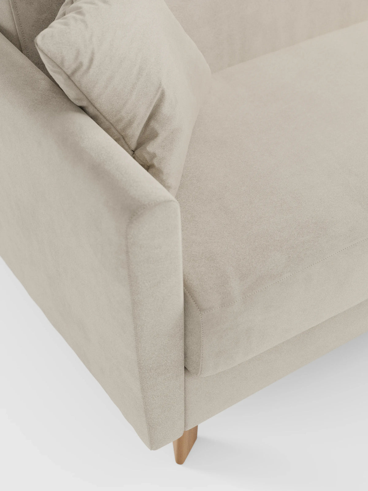 Un primo piano del divano letto Francy con poggiatesta regolabili di Divani.Il negozio ne mette in risalto l'elegante rivestimento in tessuto T30 color beige chiaro, resistente alle macchie, con fodere rimovibili al 100%, evidenziandone le linee pulite, i morbidi dettagli dei cuscini dei braccioli e della seduta e una gamba in legno visibile nell'angolo inferiore, il tutto su uno sfondo bianco a tinta unita.