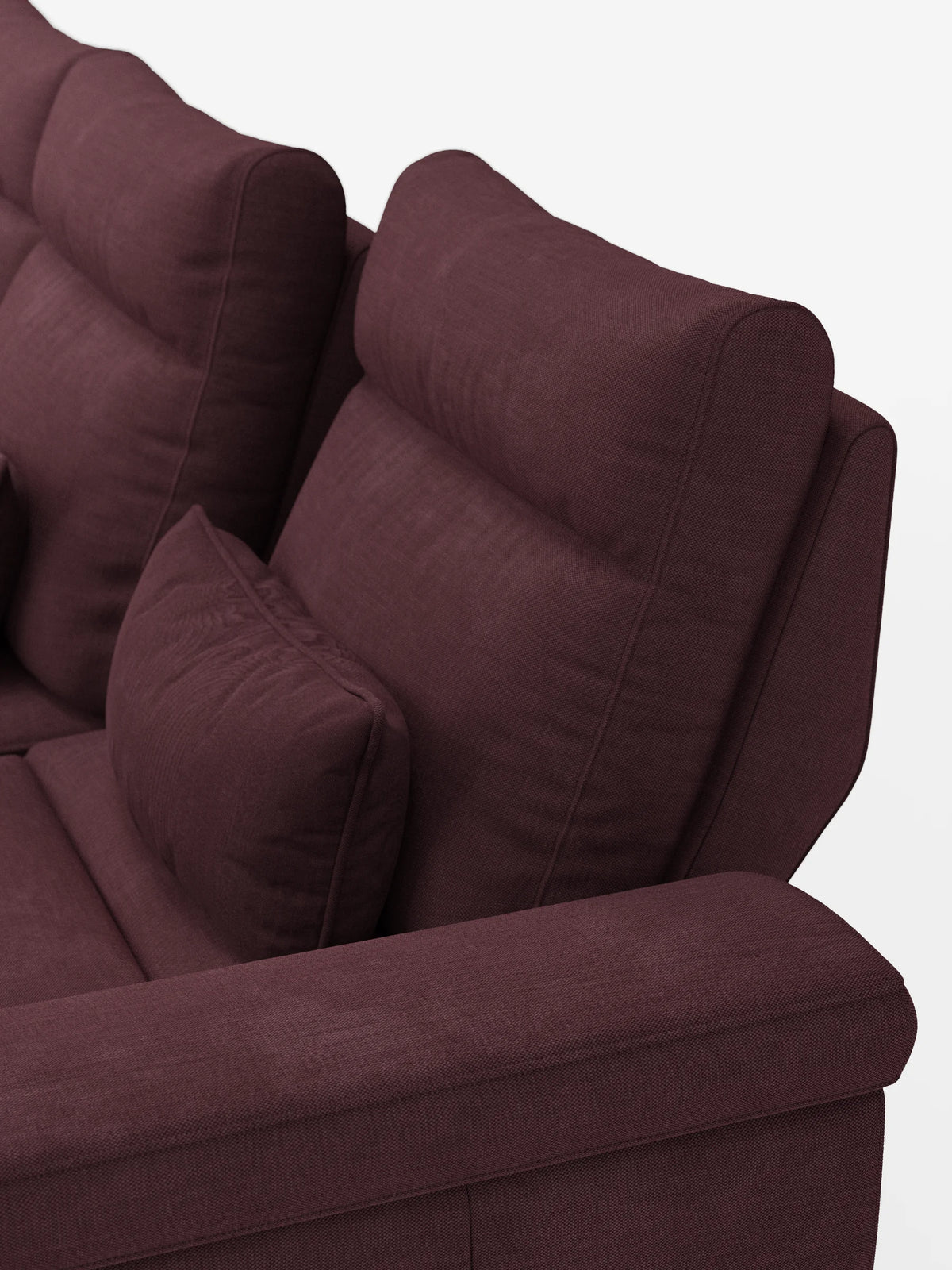 Un primo piano di un divano letto angolare Ischia di colore viola intenso con schienali scorrevoli, rivestimento testurizzato, cuscini spessi e un cuscino decorativo abbinato, su uno sfondo chiaro a tinta unita.