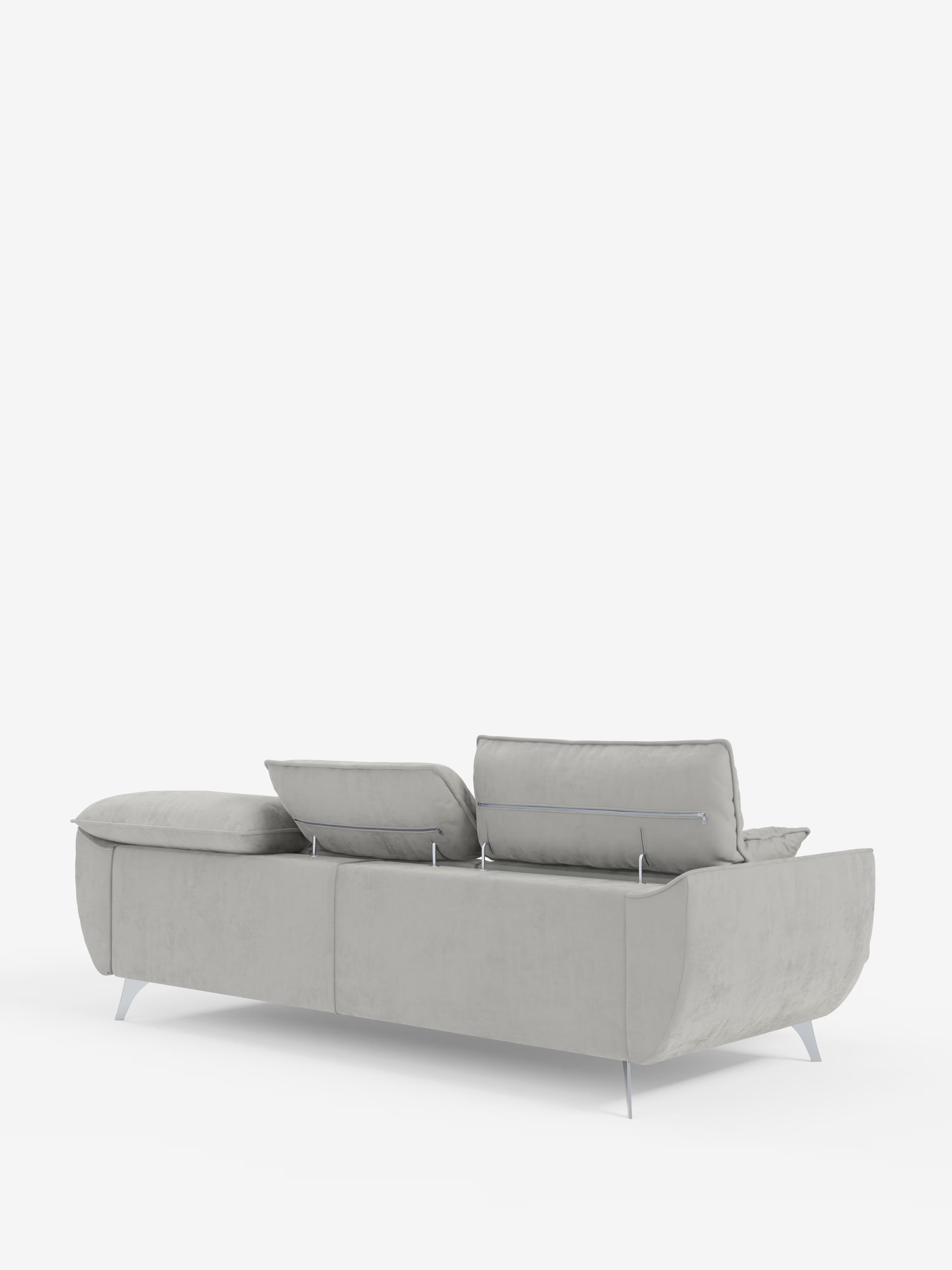 Il divano Michelangelo 4 Posti di Divani.Store è un elegante divano grigio chiaro rivestito in velluto smacchiabile T30, dotato di tre sedute estensibili e poggiatesta reclinabili. Ripreso di profilo dal retro su uno sfondo bianco a tinta unita, questo divano moderno presenta ampi cuscini rettangolari, sottili gambe in metallo e un design lineare e minimalista.