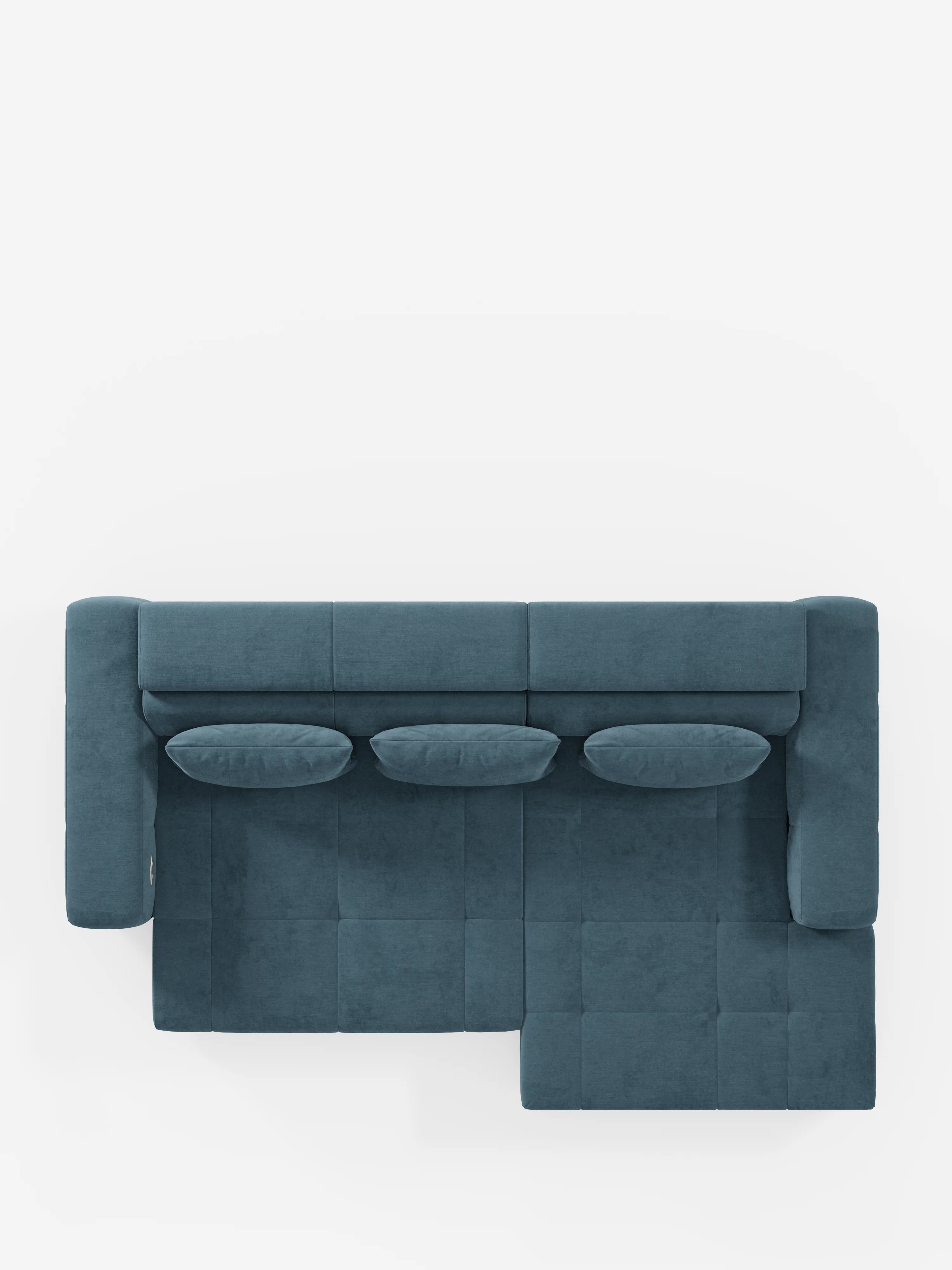 Il divano angolare Monarch blu con penisola e funzione Relax Elettrico per l'allungamento delle sedute di Divani.Store è ripreso dall'alto e presenta tre cuscini dello schienale e tre cuscini decorativi ovali abbinati, realizzati nello stesso morbido tessuto T31 facile da pulire. Il divano, dotato di poggiatesta regolabili, è posizionato su uno sfondo bianco che ne mette in risalto le sezioni rettangolari e quadrate della seduta, oltre al design pulito e moderno.