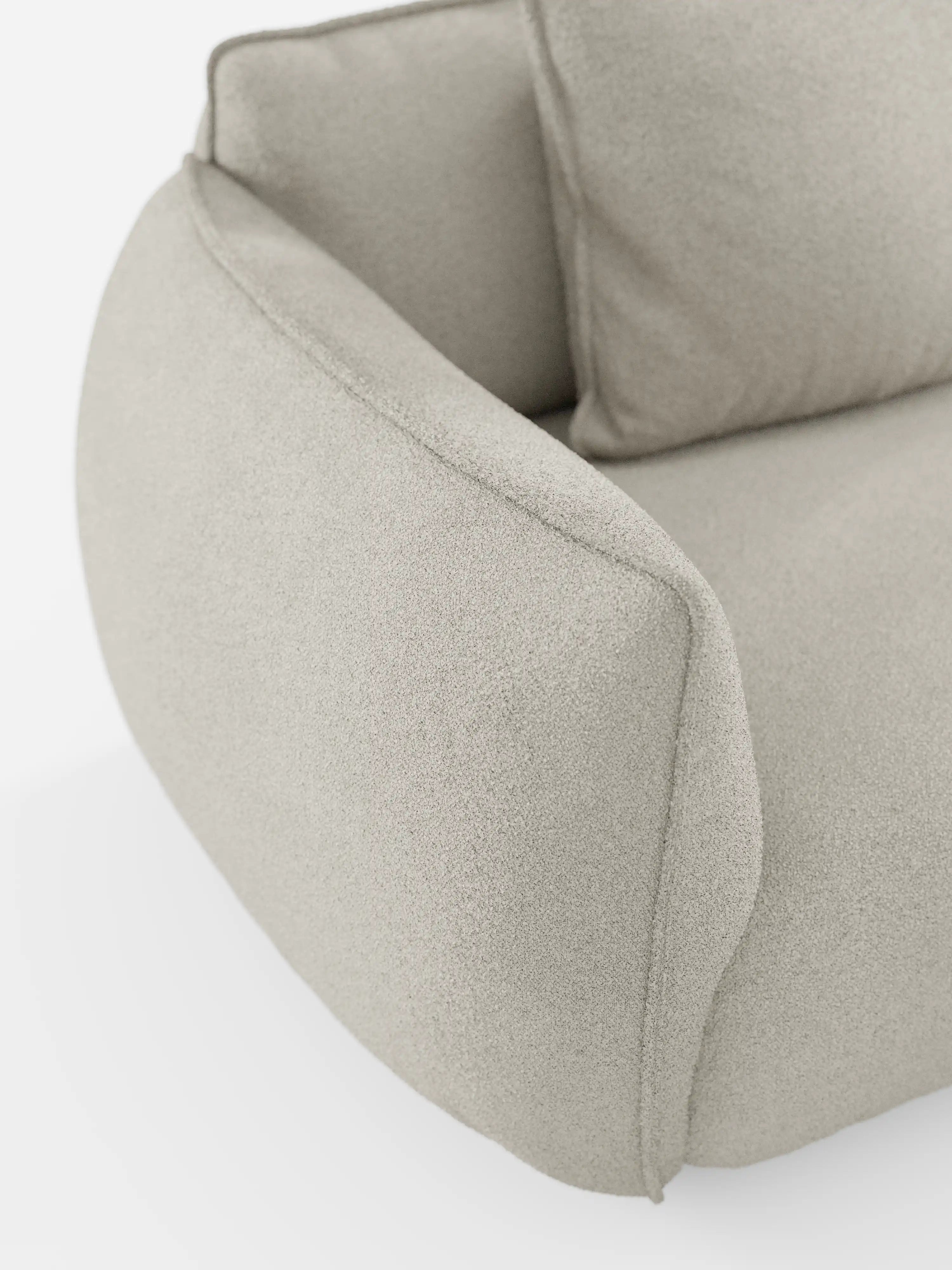 Primo piano del divano modulare a 3 posti “Nimbus” di Divani.Store, rivestito in tessuto T33 effetto cotone, resistente alle macchie, color beige chiaro. L’immagine mette in risalto un bracciolo e parte del cuscino della seduta, evidenziando le forme morbide e arrotondate e il rivestimento soffice tipici di questo divano modulare moderno, su uno sfondo bianco.