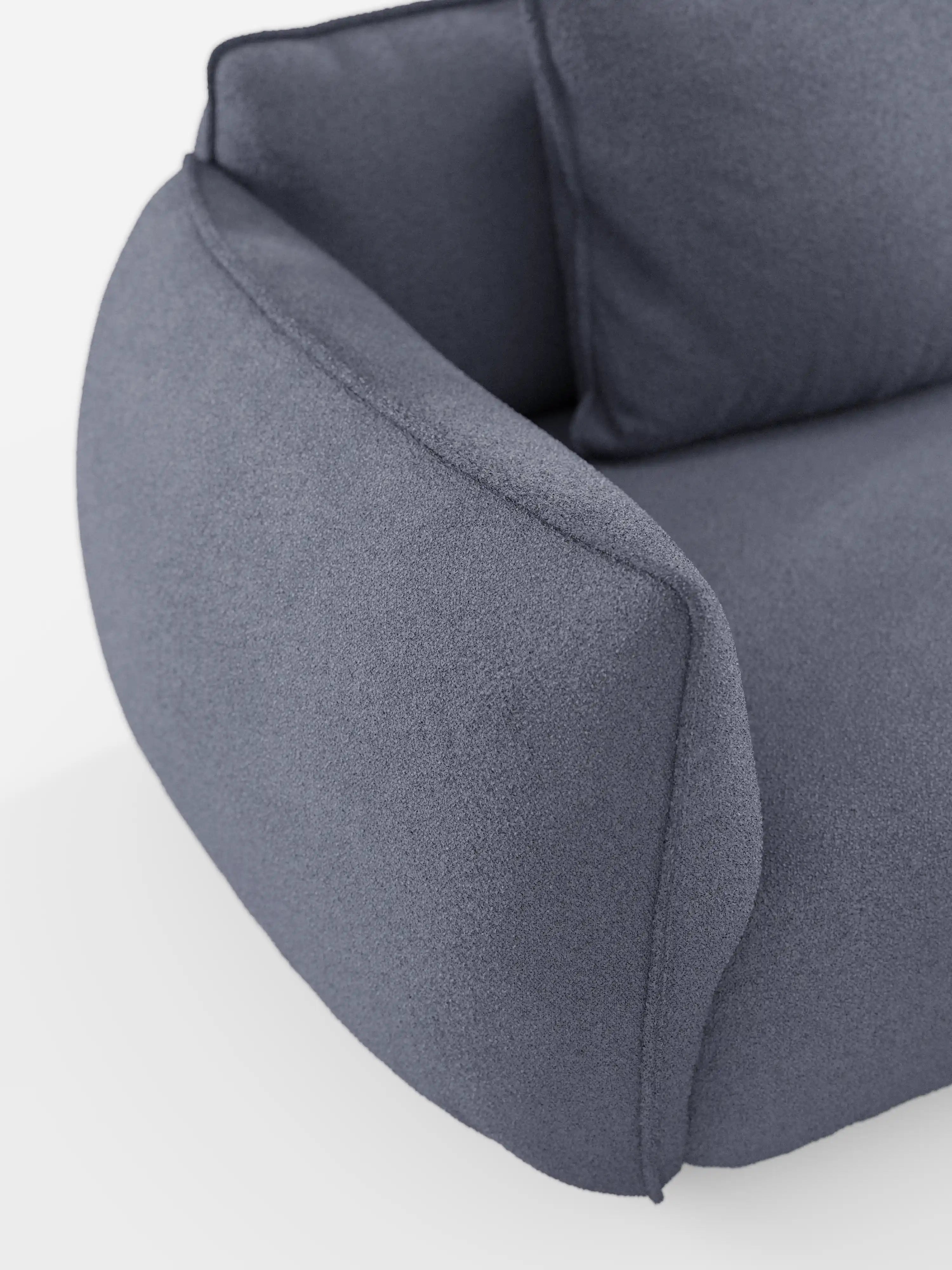 Un primo piano del divano modulare a 3 posti “Nimbus” di Divani.Store, rivestito in morbido tessuto T33 effetto cotone, resistente alle macchie. L'immagine mette in risalto il design moderno con il rivestimento grigio testurizzato, gli ampi braccioli arrotondati e i morbidi cuscini — che richiamano il vero comfort modulare — con solo una parte dello schienale, della seduta e di un bracciolo visibili su uno sfondo bianco a tinta unita.