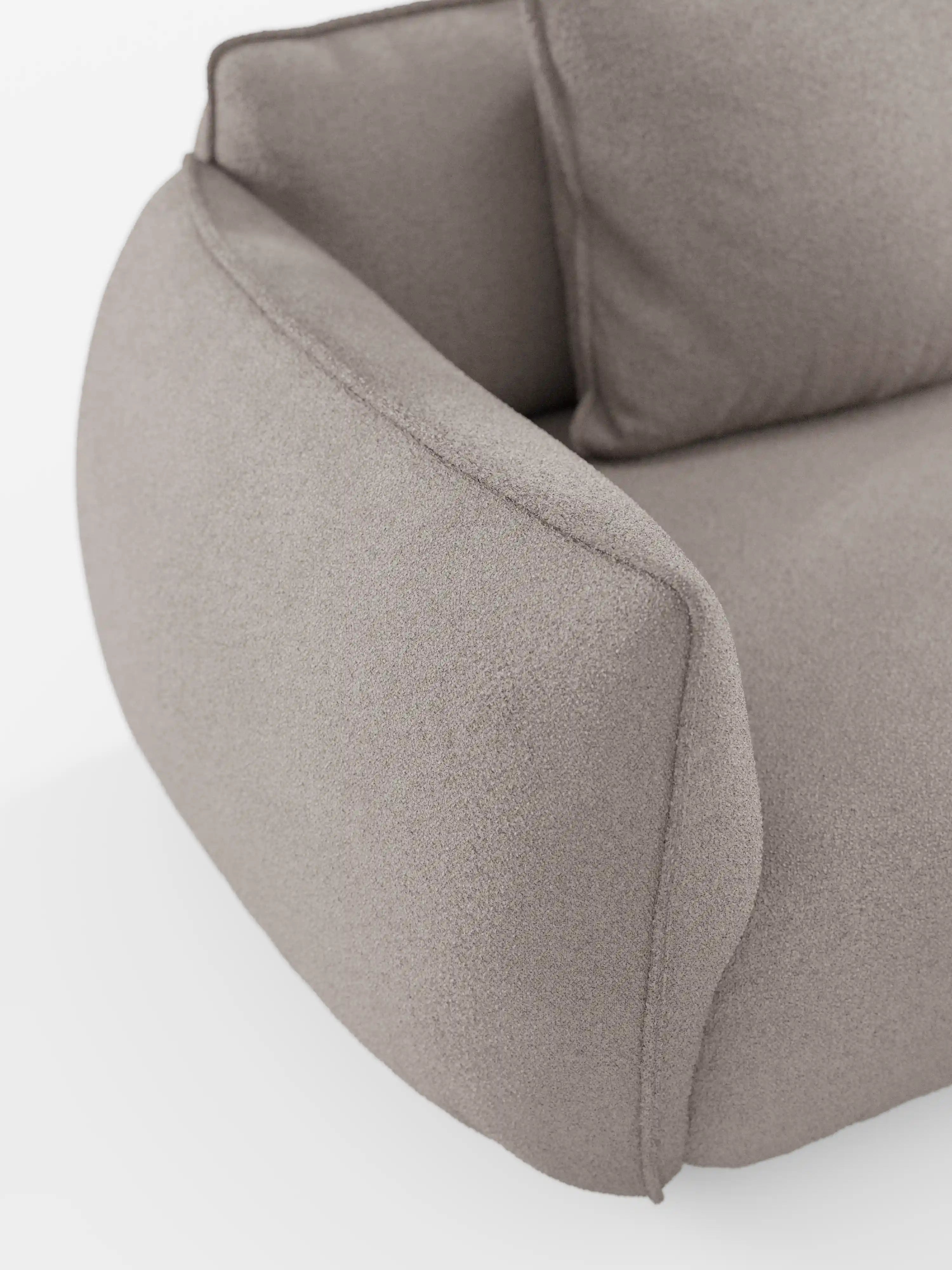 Primo piano del divano modulare a 3 posti “Nimbus” di Divani.Store, rivestito in tessuto T33 effetto cotone beige chiaro e resistente alle macchie. Il bracciolo è arrotondato e massiccio, caratterizzato da linee morbide e senza cuciture che richiamano il design contemporaneo di un divano modulare. Parte del cuscino di seduta e dello schienale sono visibili su uno sfondo bianco a tinta unita.