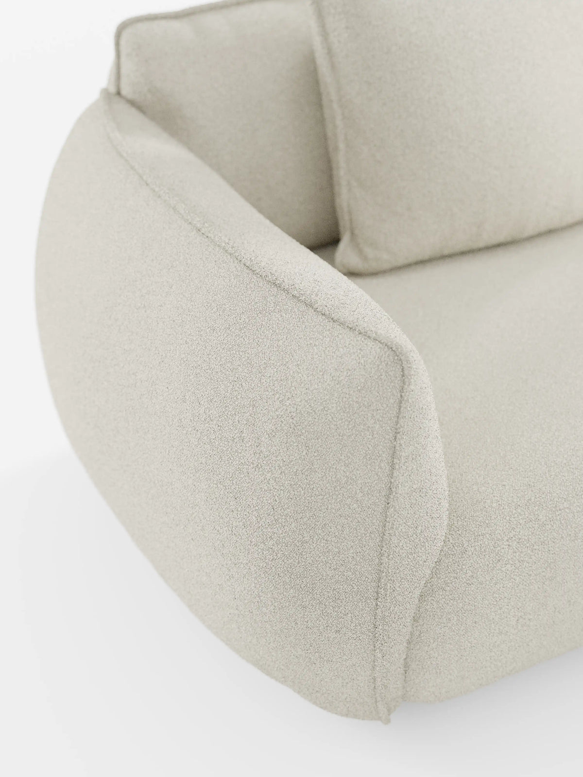 Primo piano del divano Nimbus a 3 posti, modulare e componibile, da 250 cm di Divani.Store, rivestito in tessuto smacchiabile effetto cotone (tessuto smacchiabile effetto cotone t33) di colore beige chiaro. Ispirata al design dei divani modulari, questa poltrona presenta un bracciolo ricurvo verso l’esterno e uno schienale morbido e imbottito. Il look complessivo è lussuoso e contemporaneo, caratterizzato da linee pulite e arrotondate.