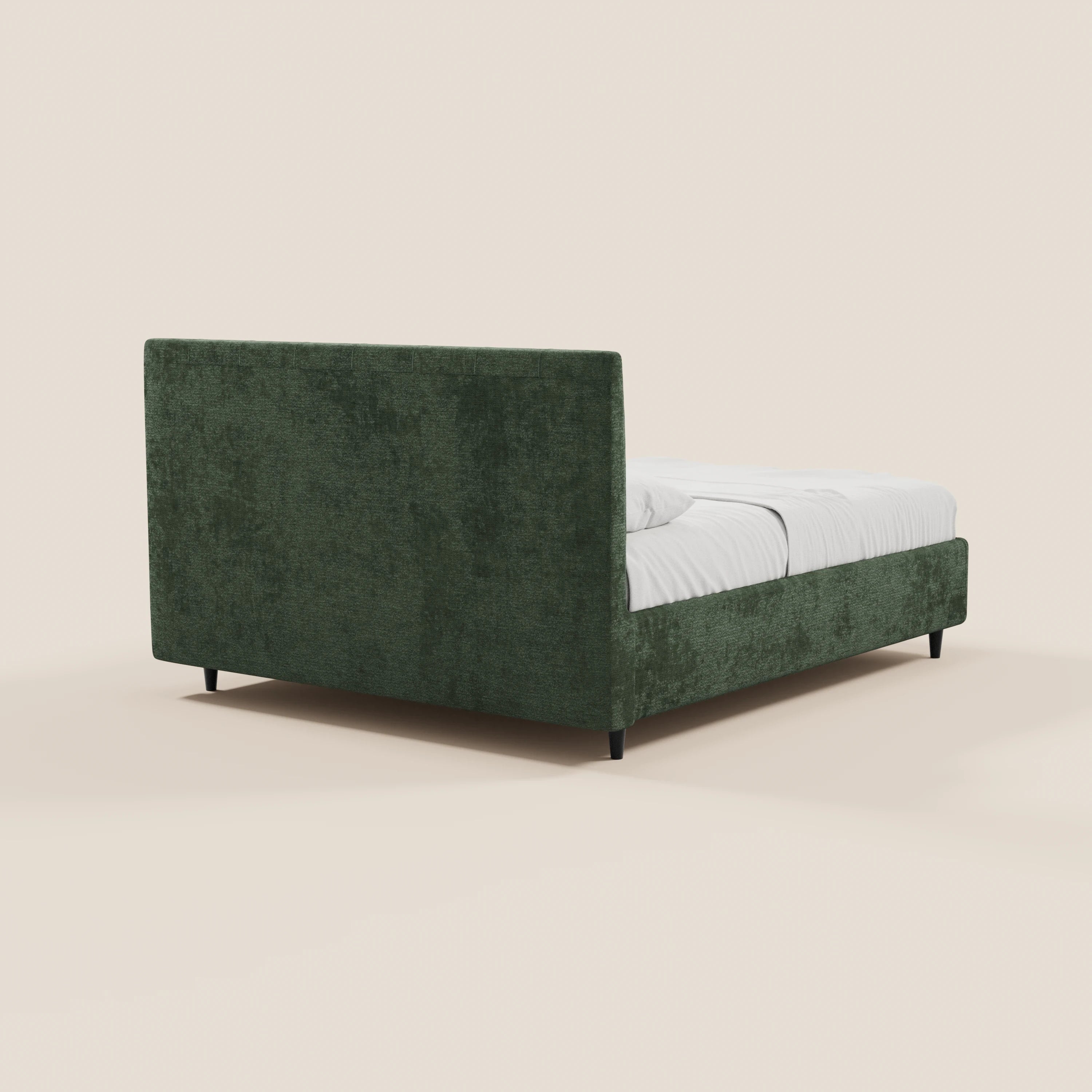 Il letto imbottito con contenitore ONYX di Letti.store presenta una struttura in tessuto verde scuro certificato Oeko-Tex®, una testiera verticale, gambe corte nere, un design dal profilo basso e biancheria da letto bianca; è raffigurato in una prospettiva laterale posteriore su uno sfondo bianco sporco.
