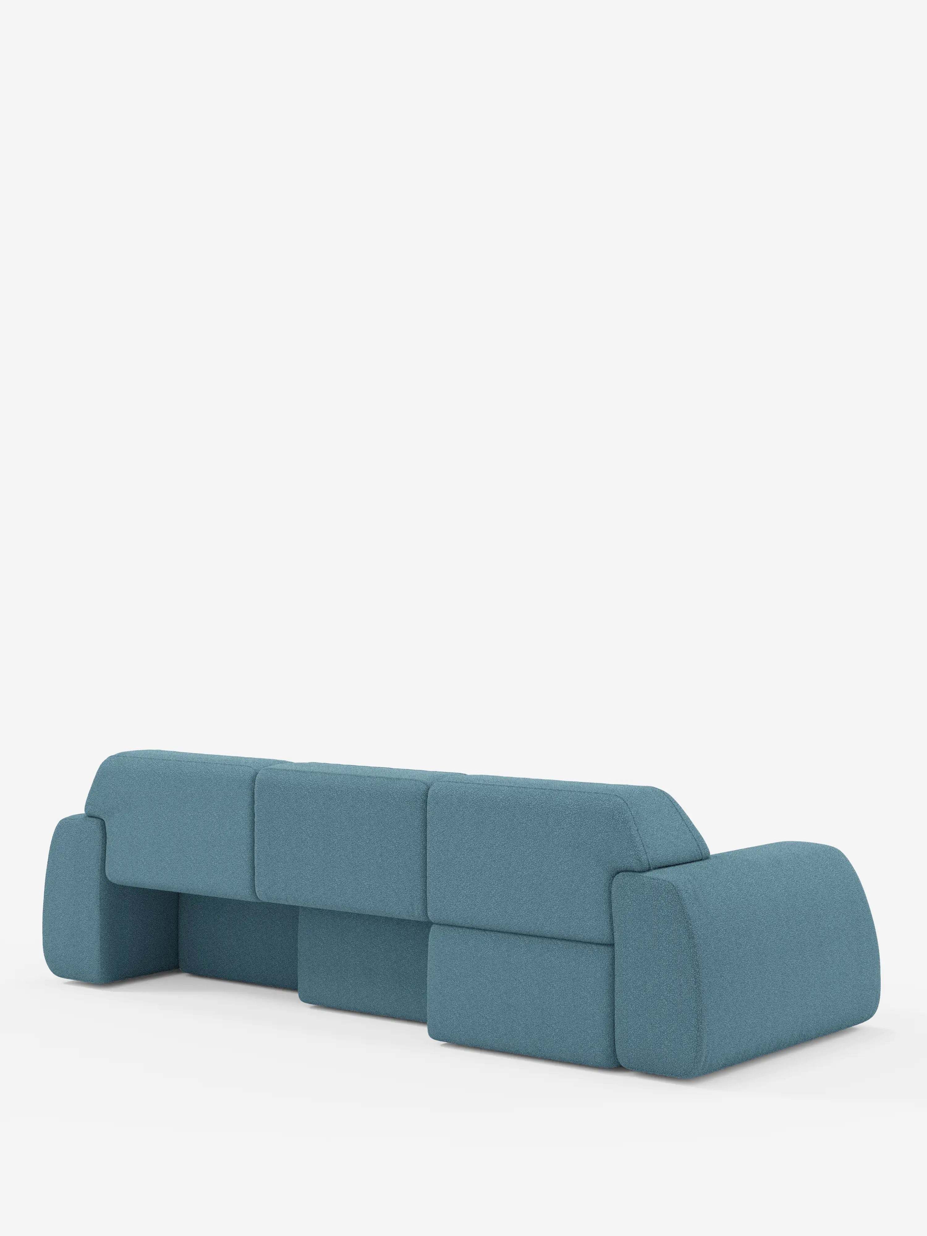Un divano Orbit moderno e minimalista con 3 sedute scorrevoli e allungabili in tessuto effetto cotone smacchiabile T33 di Divani.Store, caratterizzato da uno schienale basso e da cuscini blu arrotondati e squadrati. Presentato su uno sfondo bianco a tinta unita, questo divano offre un design geometrico spazioso senza gambe a vista ed è completamente sfoderabile per una facile pulizia.