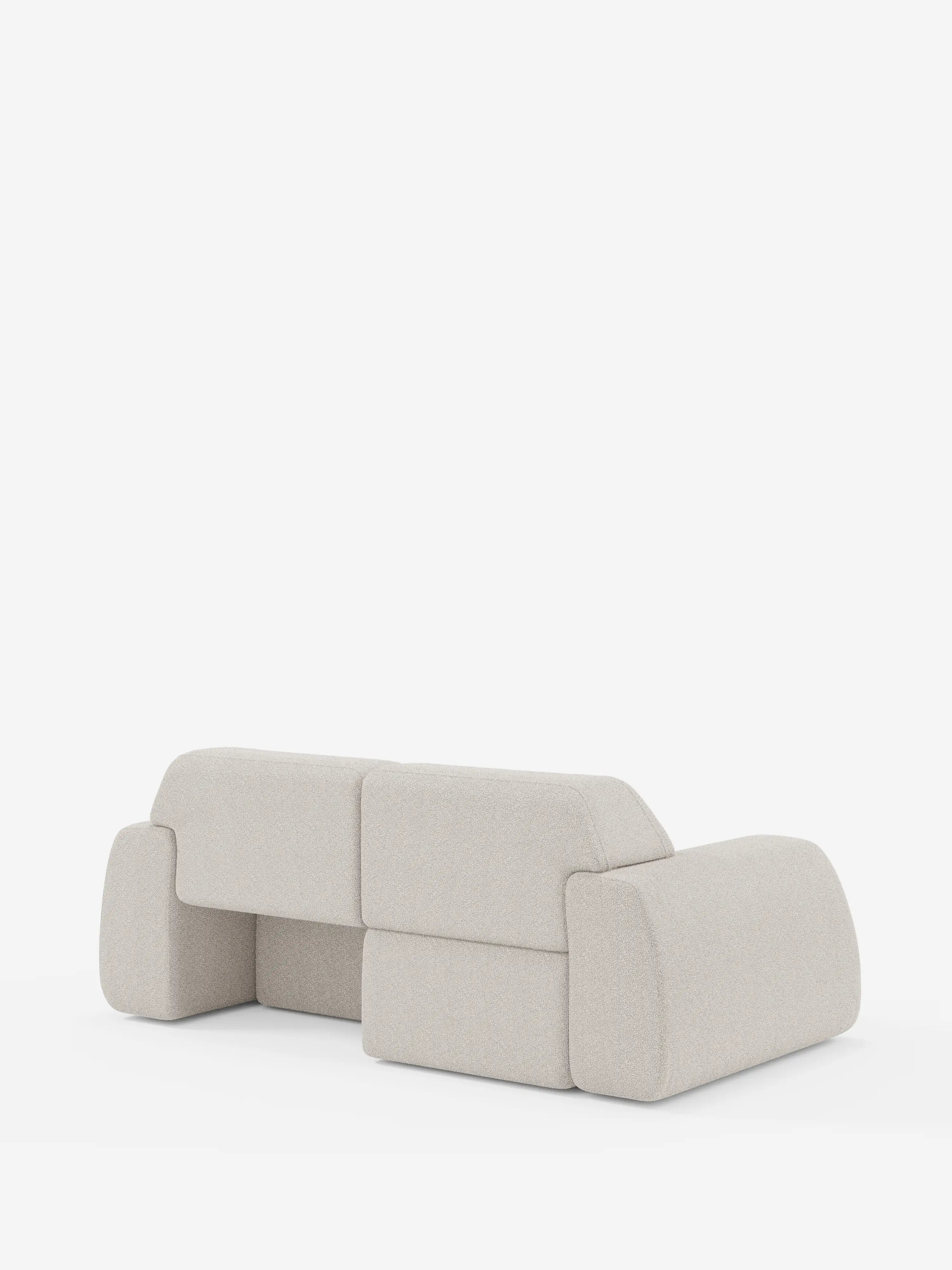 Un moderno divano a 3 posti Orbit di Divani.Store, rivestito in tessuto T33 beige chiaro, smacchiabile ed effetto cotone, è raffigurato su uno sfondo bianco. Caratterizzato da cuscini spessi e squadrati e da bordi arrotondati, il divano presenta un design minimalista e geometrico ed è ripreso da dietro e leggermente di lato. Il modello è dotato di sedute scorrevoli ed è completamente sfoderabile per una facile pulizia.