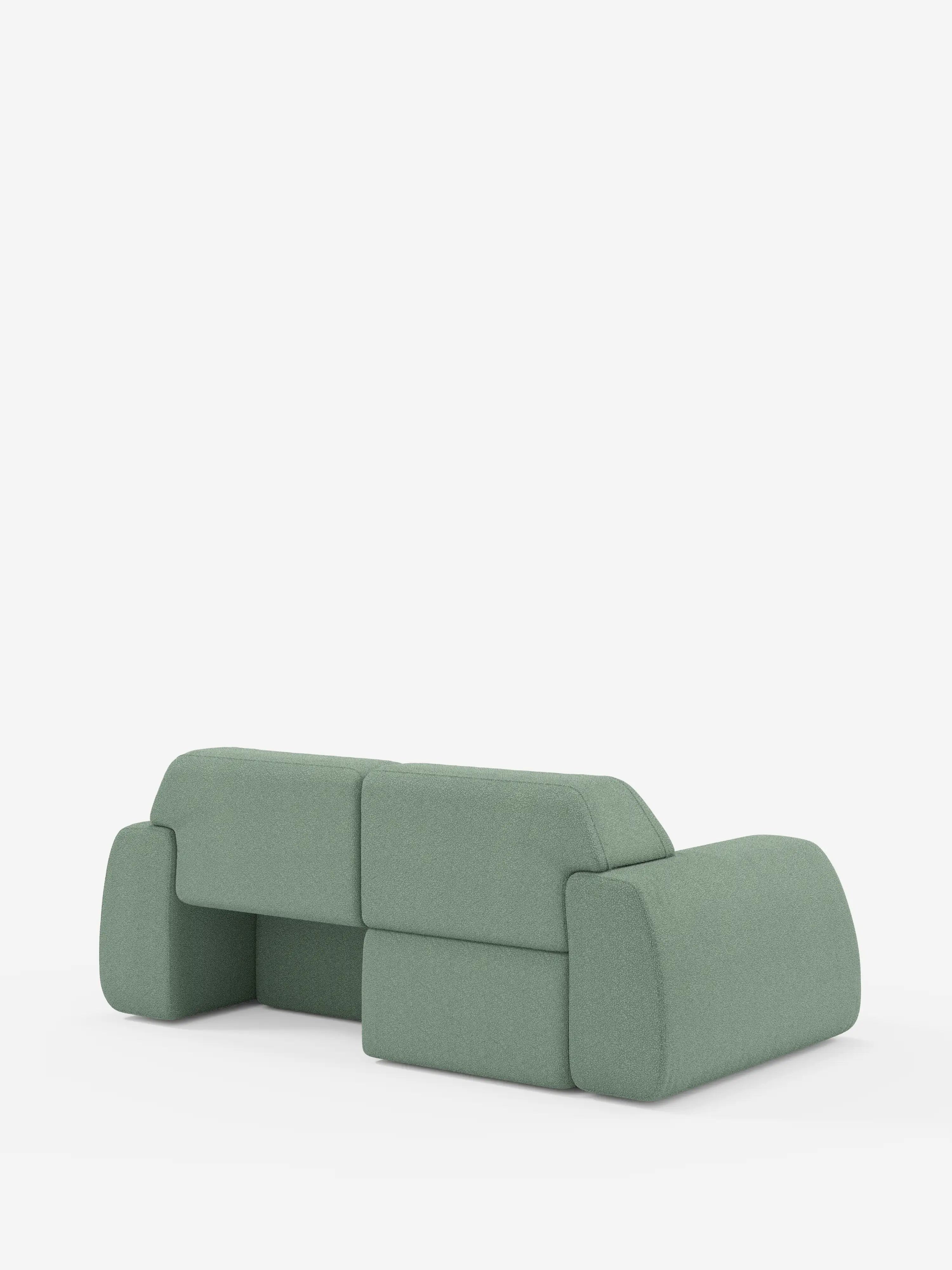 Un elegante divano Orbit a 2 e 3 posti in verde salvia con sedute scorrevoli di Divani.Store spicca su uno sfondo bianco. Questo divano completamente sfoderabile, rivestito in tessuto T33 effetto cotone di facile pulizia, presenta bordi arrotondati e un profilo basso e modulare. I cuscini dello schienale e dei braccioli, spessi e morbidi, gli conferiscono un fascino delicato e minimalista che incarna l’essenza del design contemporaneo.