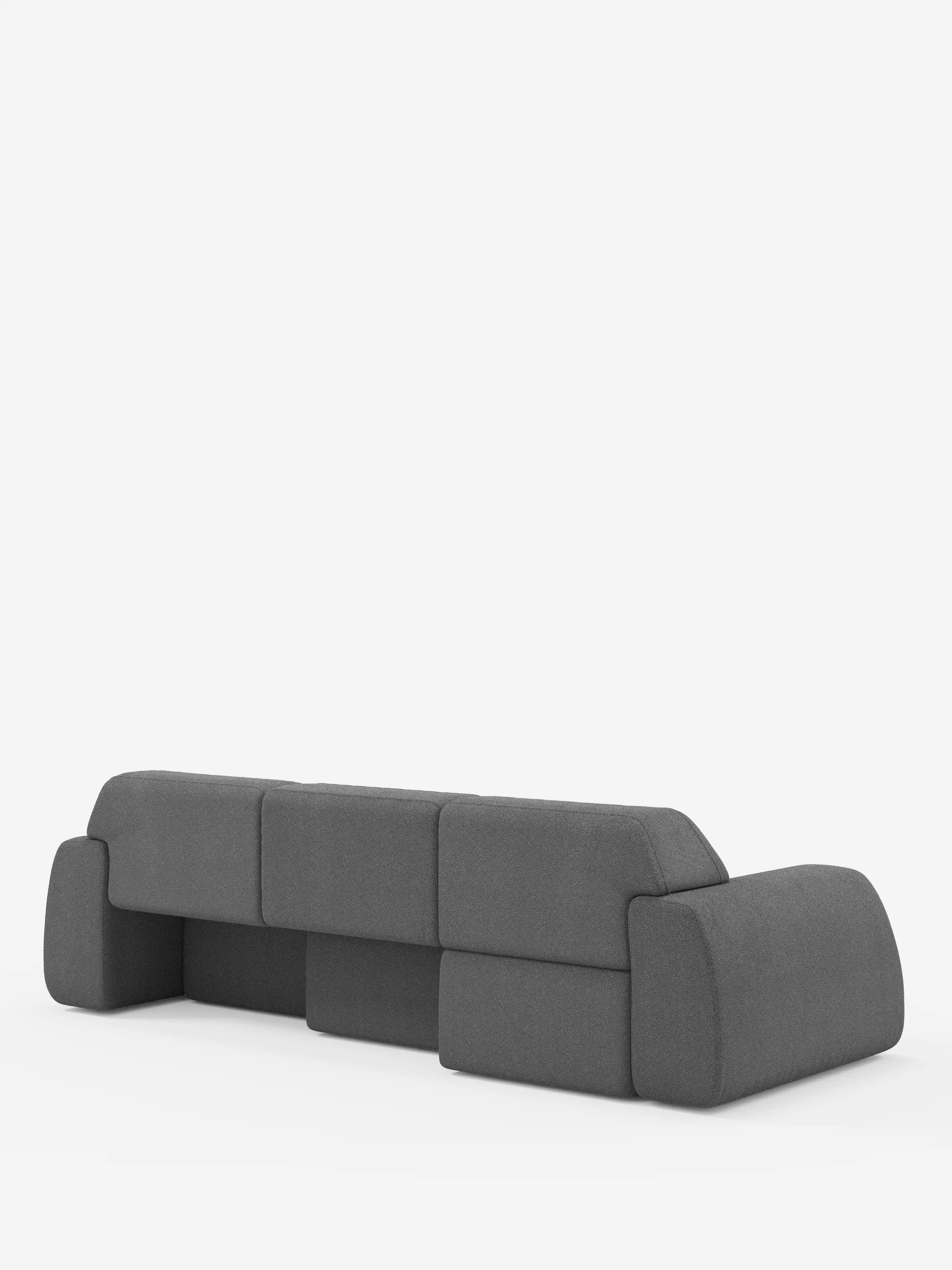 Un divano angolare Orbit in stile contemporaneo con penisola reversibile e tutte le sedute allungabili, rivestito in tessuto smacchiabile effetto cotone T33 di Divani.Store, caratterizzato da un rivestimento in tessuto grigio scuro, schienale basso, ampi braccioli e bordi arrotondati e morbidi, è posizionato su uno sfondo bianco a tinta unita. Il design minimalista e squadrato del divano offre comodamente posto a quattro persone e trasmette un fascino di alta gamma.