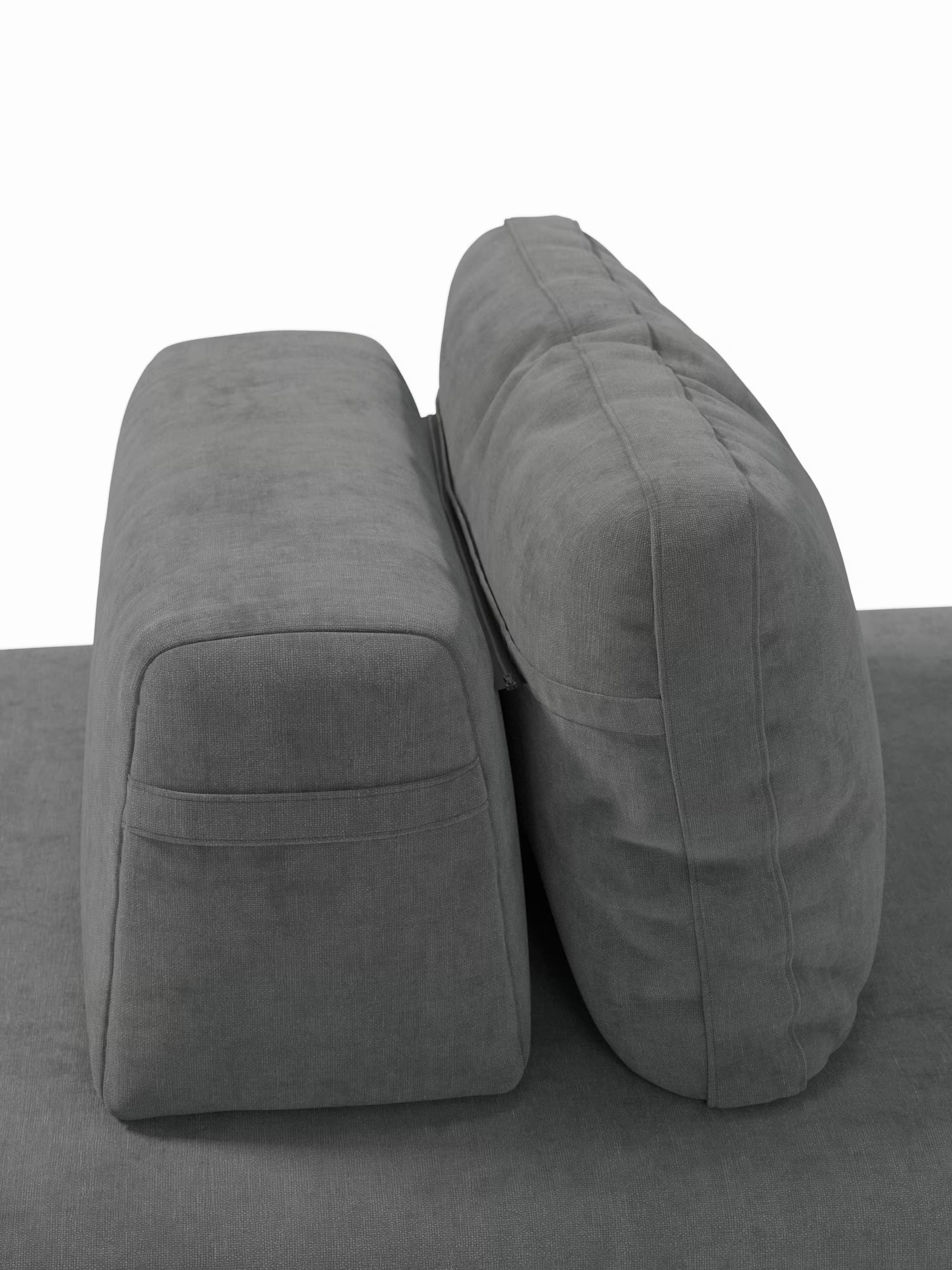 Un primo piano di due cuscini rettangolari grigi, disposti in verticale e affiancati su una superficie imbottita grigia abbinata, parte del divano letto matrimoniale Rift a 2 e 3 posti con schienali mobili di Divani.Store, dotato di un materasso in memory foam alto 22 cm nella versione T31, su uno sfondo bianco a tinta unita.