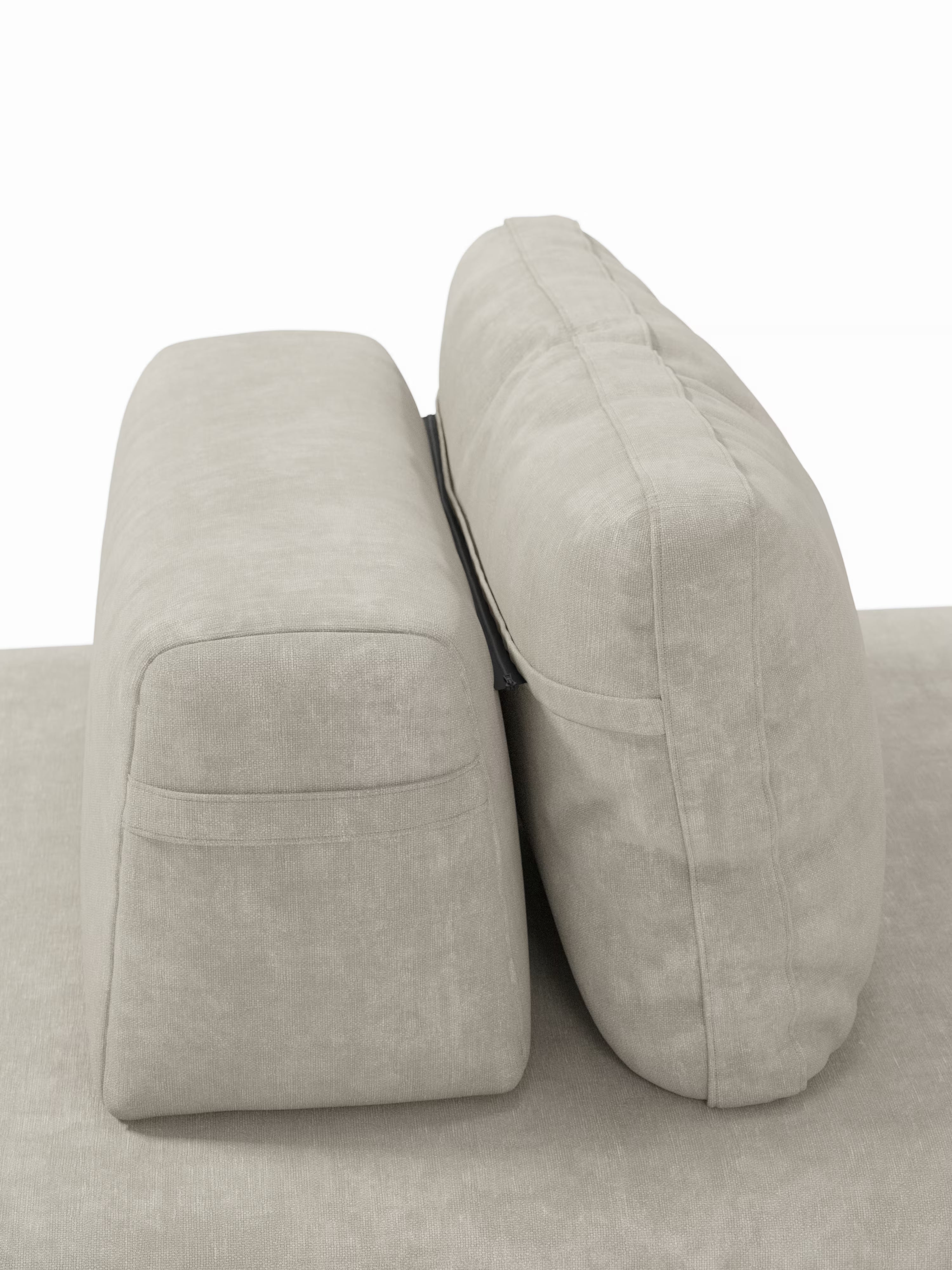 Due cuscini schienali rettangolari color beige chiaro sono disposti verticalmente uno accanto all’altro sulla base abbinata del divano letto matrimoniale Rift a 2 e 3 posti con schienali mobili di Divani.Store. Il cuscino di sinistra presenta bordi dritti e una cucitura nella parte superiore, mentre quello di destra è più alto, più imbottito e presenta una cucitura orizzontale ben visibile.