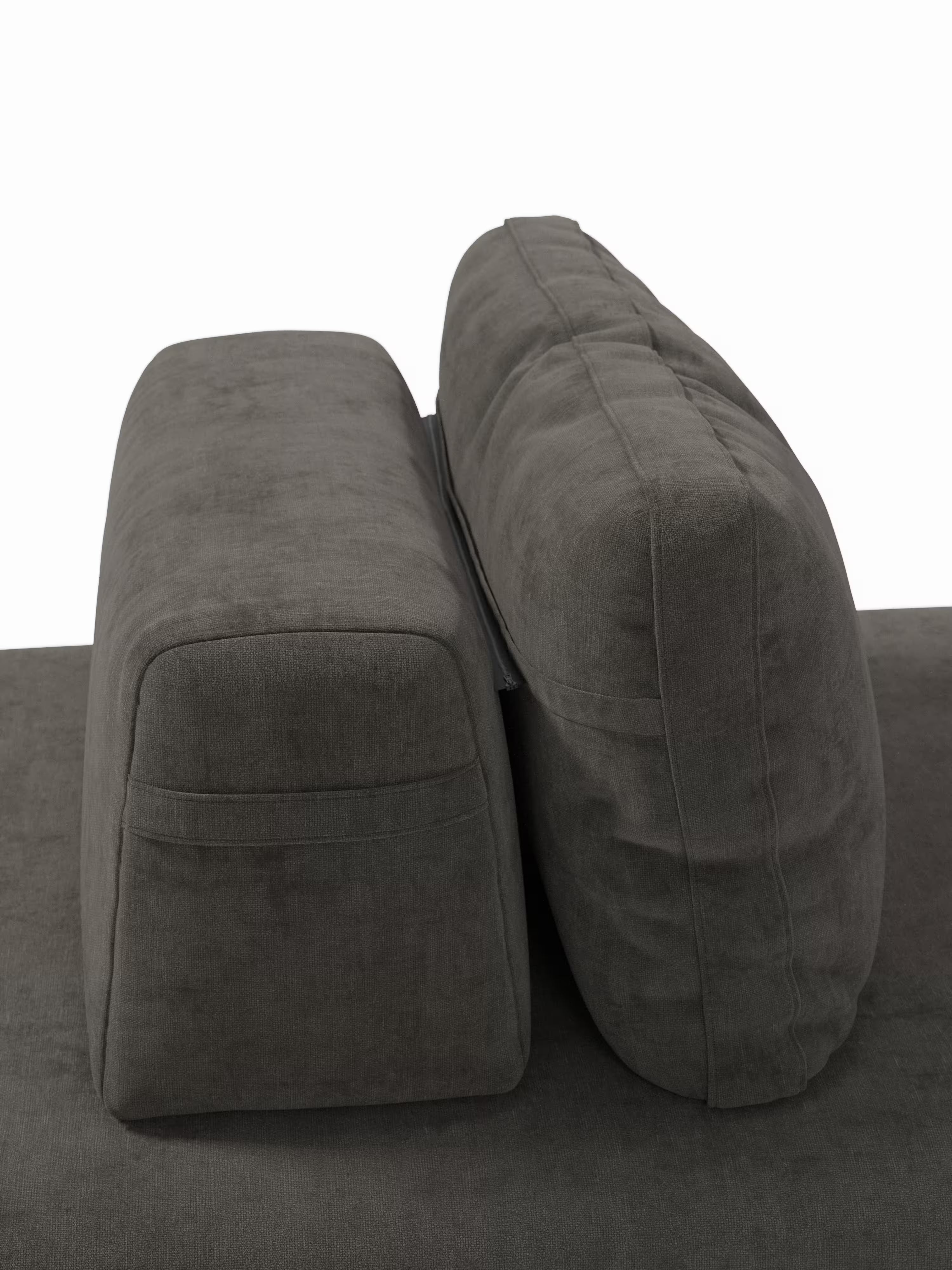Una vista laterale ravvicinata del divano letto matrimoniale Rift a 2 e 3 posti di Divani.Modello con rivestimento in grigio scuro, che mette in risalto il cuscino di seduta rettangolare e spesso sulla sinistra e l’alto e morbido cuscino dello schienale mobile sulla destra — entrambi posizionati su una base in tessuto coordinato con un materasso in memory foam T31 alto 22 cm — il tutto su uno sfondo bianco.