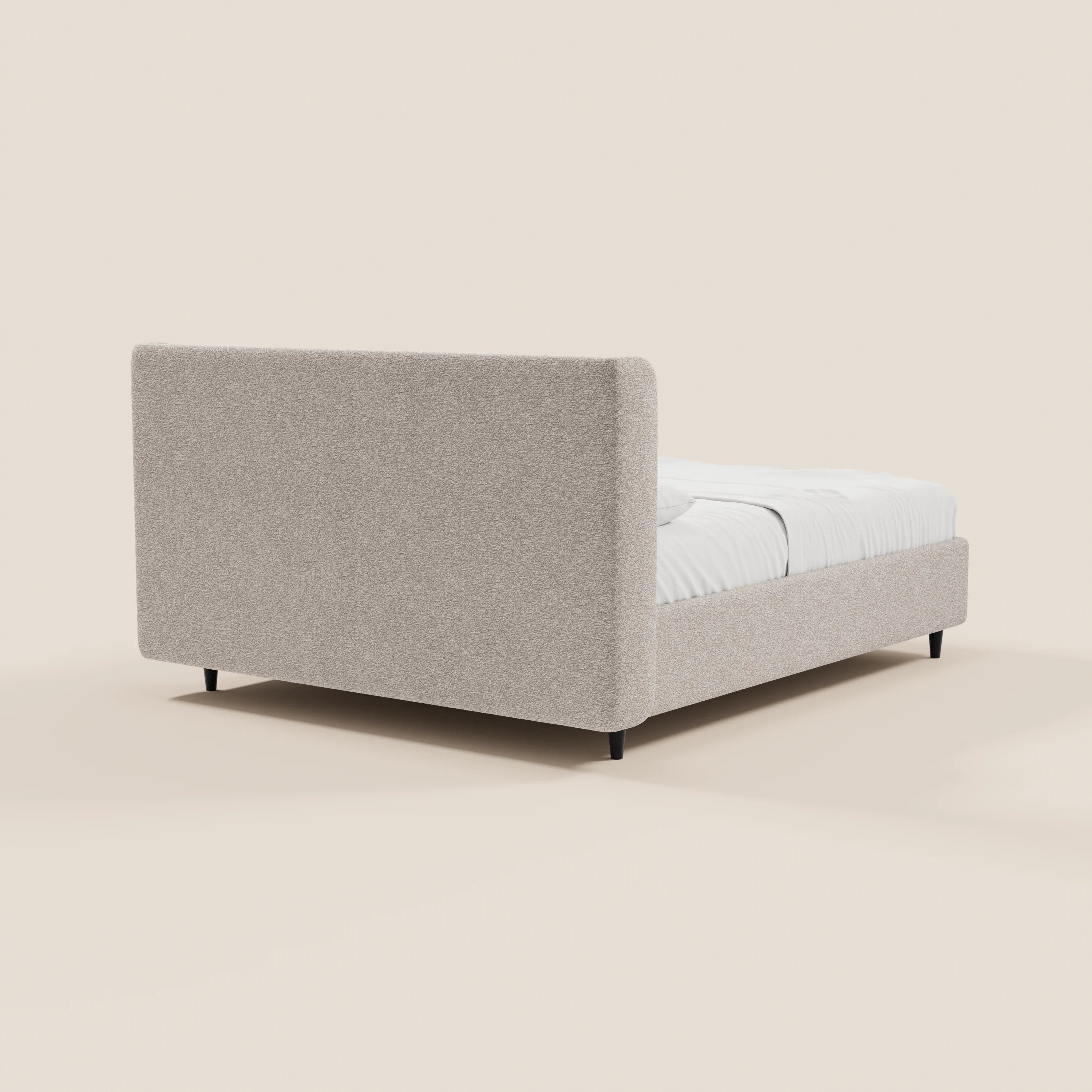 Il modello VALKIRIA di Letti.store, un letto di design con contenitore e testiera avvolgente, è presentato in tessuto beige chiaro Oeko-Tex®, con due cuscini imbottiti e gambe nere corte su uno sfondo minimalista, per un look contemporaneo.