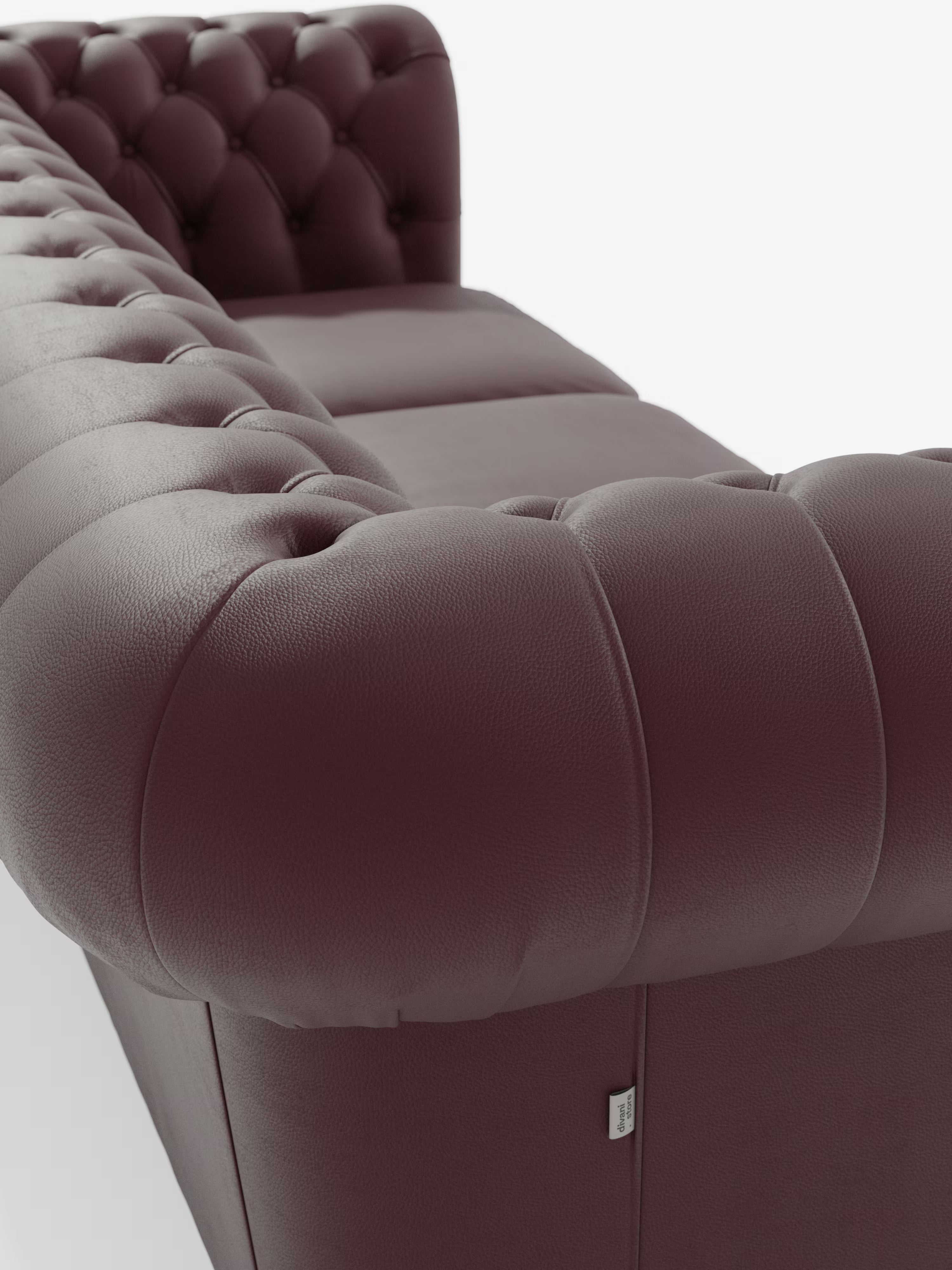 Primo piano del divano Chester 4 Posti 3 sedute in vera pelle – Chesterfield Capitonné Artigianale di Divani.Store, che mette in risalto la profonda trapuntatura a bottoni sui braccioli e sullo schienale arrotondati. L'attenzione è concentrata sulla ricca trama della pelle marrone scuro del divano e sulla lavorazione artigianale, in contrasto con uno sfondo bianco a tinta unita.