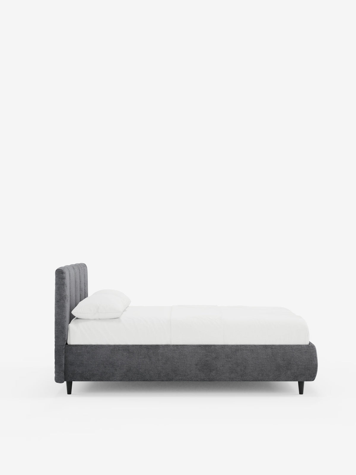 Un letto in stile shabby chic — il letto imbottito ARKAM di Letti.store — caratterizzato da una testiera in tessuto con cuciture verticali, certificata Oeko-Tex®, e da un vano contenitore integrato, rivestito in grigio e ripreso di profilo con biancheria da letto bianca e un unico cuscino su uno sfondo bianco a tinta unita.