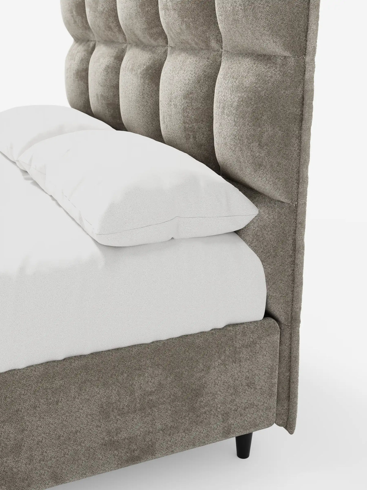 Un primo piano di un letto imbottito AURO con contenitore e testiera alta capitonné in ciniglia Oeko-Tex®, caratterizzato da una testiera alta imbottita e capitonné color taupe, una struttura rivestita in tessuto e biancheria da letto bianca su uno sfondo a tinta unita.