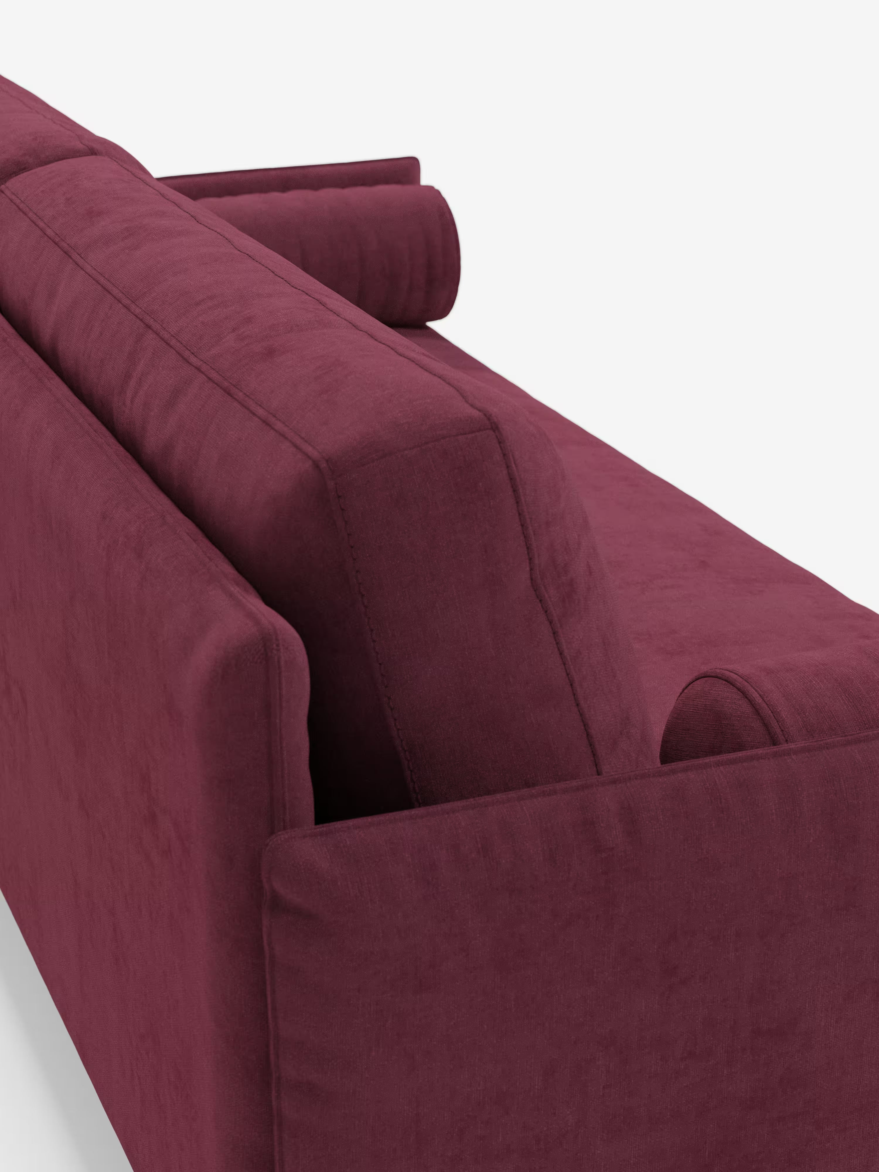 Un primo piano del divano lineare a 2 posti “Basalto” di Divani.Store, rivestito in tessuto T31 color bordeaux intenso e resistente alle macchie, mette in risalto lo schienale e i fianchi del divano. È visibile anche un cuscino cilindrico coordinato, il cui sfondo bianco accentua sia il design minimalista sia la trama del suo rivestimento sfoderabile.