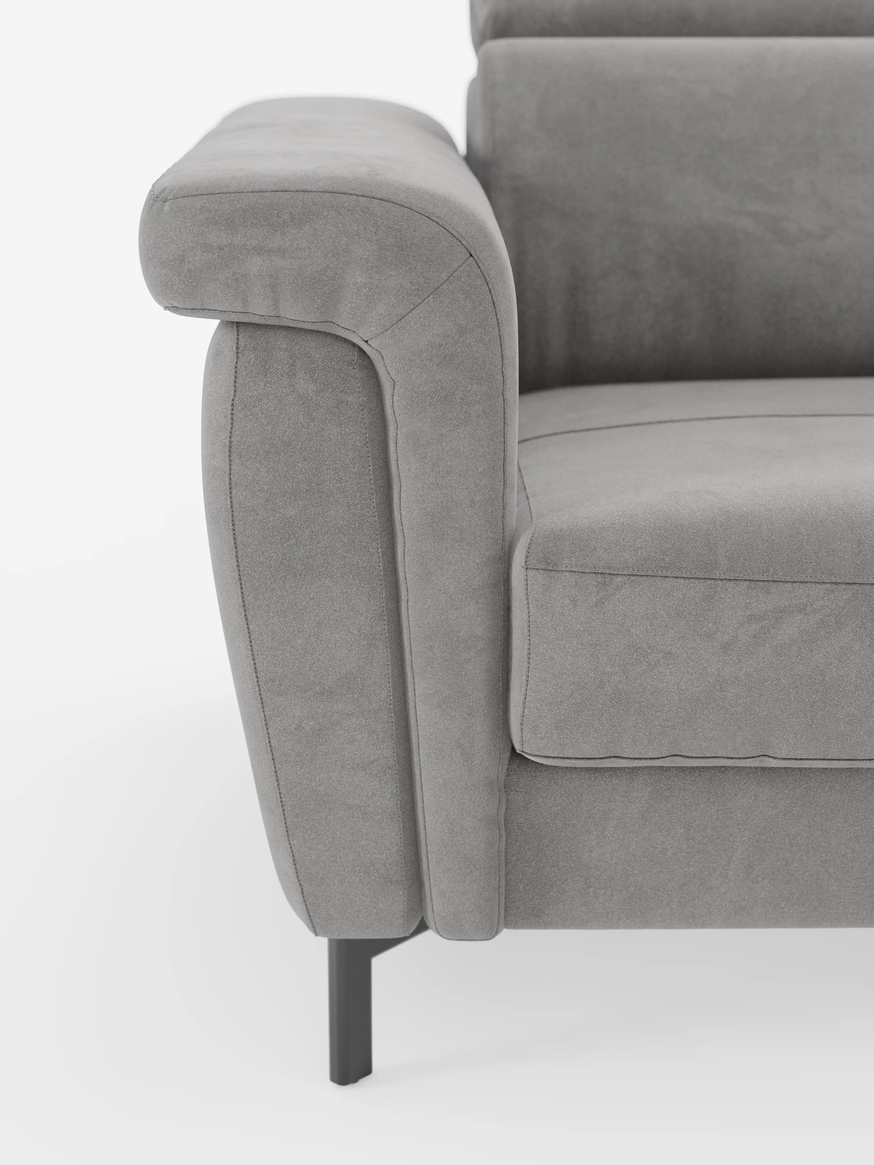 Primo piano del bracciolo sinistro e della seduta del divano letto di design Capri di Divani.Store, caratterizzato da alte gambe in metallo nero, morbido tessuto T30 effetto velluto simile alla pelle scamosciata e smacchiabile, e imbottitura morbida e raffinata con poggiatesta regolabili, ripreso su uno sfondo bianco a tinta unita.