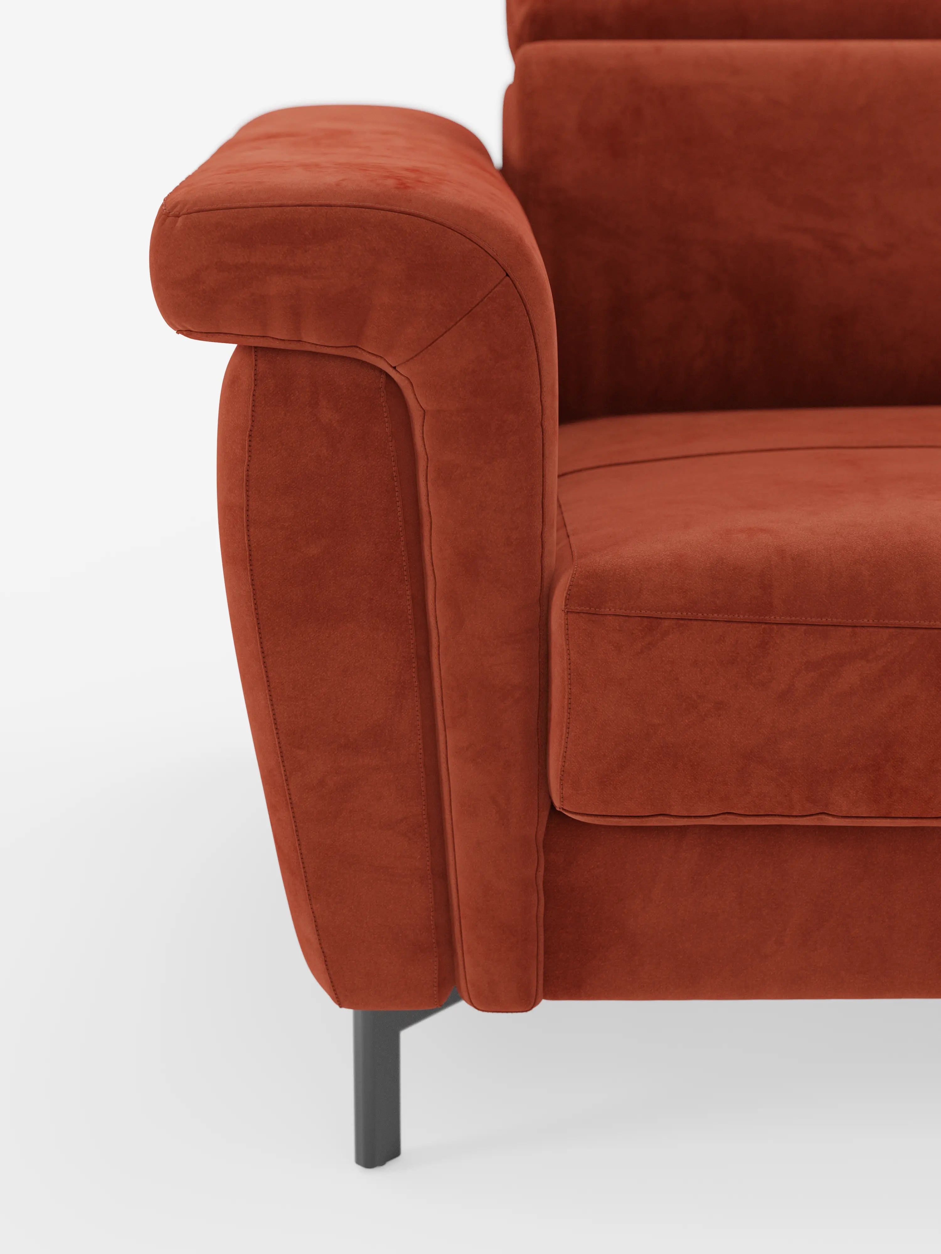 Primo piano del divano letto di design Capri di Divani.Store, rivestito in tessuto T30 effetto velluto color ruggine e resistente alle macchie sul bracciolo sinistro, sul cuscino della seduta e sullo schienale. La poltrona presenta linee pulite e moderne con poggiatesta reclinabile e poggia su alte gambe in metallo nero su uno sfondo bianco.