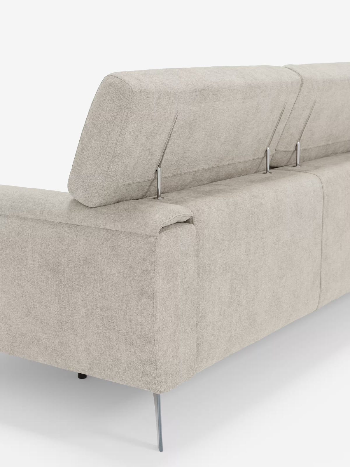 Un moderno divano Caravaggio grigio chiaro a 4 posti con tre sedute scorrevoli di Divani.Store, rivestito in tessuto T31 antimacchia, con sottili gambe in metallo visibili dal retro. Lo schienale è suddiviso in sezioni e presenta due poggiatesta regolabili in verticale, sostenuti da barre metalliche a vista. Questo divano moderno vanta uno stile minimalista e contemporaneo.