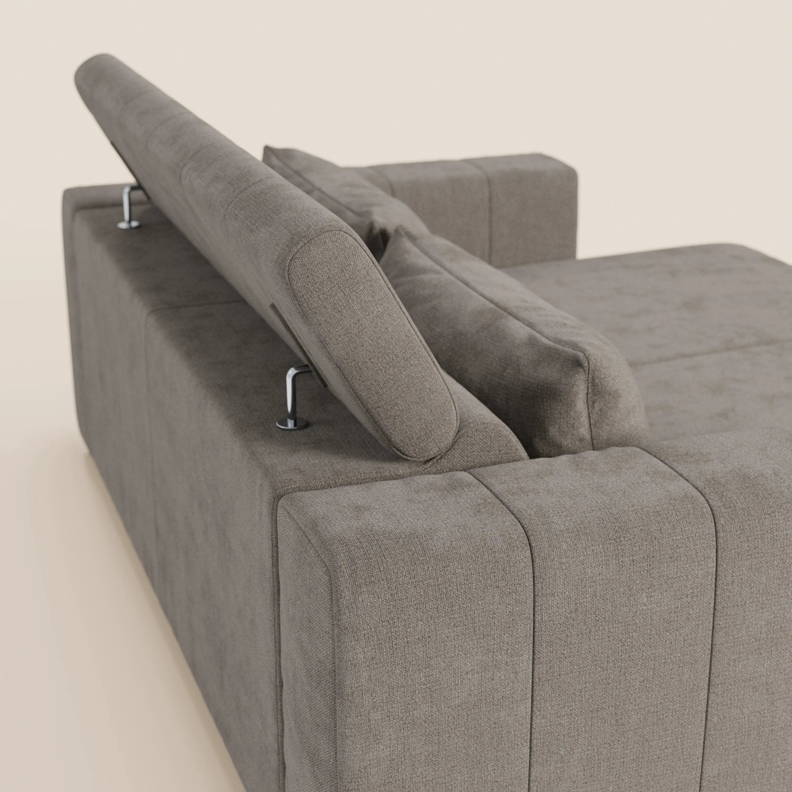 Il divano Doric 3 posti di Divani.Store, presentato dallo schienale in tessuto antimacchia T23 marrone chiaro, presenta una silhouette rettangolare, un poggiatesta reclinabile regolabile con supporti argentati a vista, ampi braccioli e un cuscino coordinato.