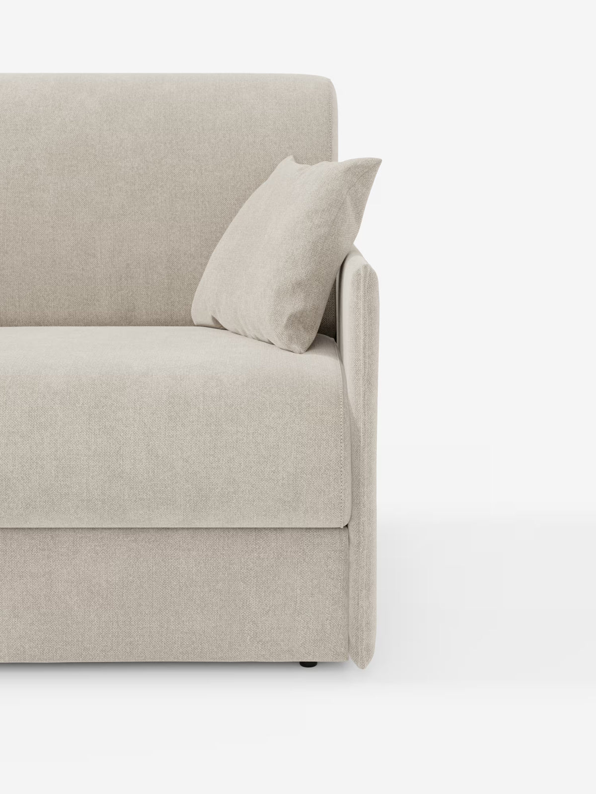 Una vista parziale del divano letto matrimoniale sfoderabile Evans di Divani.Store, caratterizzato da un rivestimento in tessuto T23 beige chiaro smacchiabile, cuscino decorativo abbinato, bracciolo sul lato destro e un design minimalista con una silhouette compatta e vano porta-cuscini integrato. Posizionato su uno sfondo bianco a tinta unita, questo divano letto dal design all’avanguardia mette in risalto le linee pulite e la morbida consistenza del tessuto.